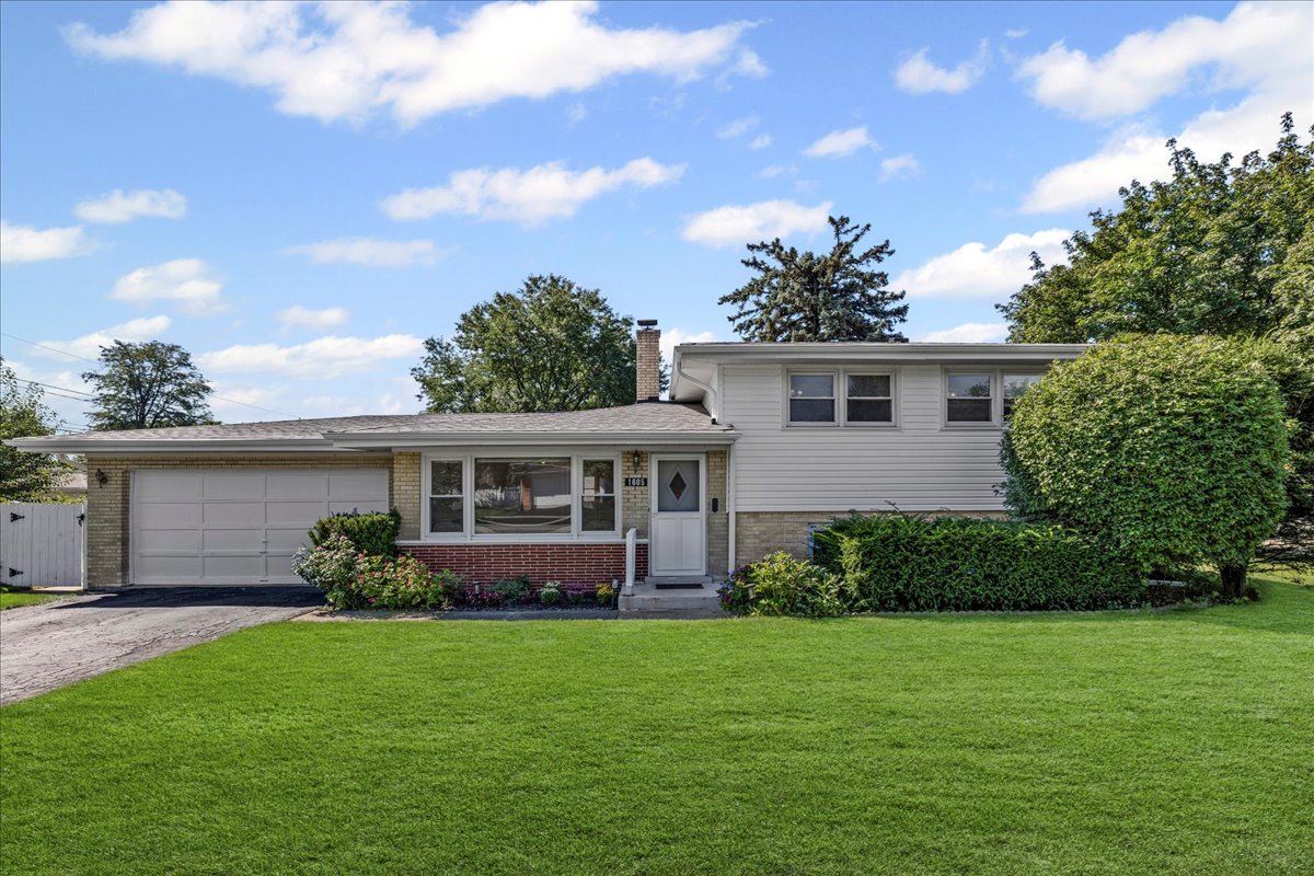 Welcome to this mid century gem tucked away in the desirable Stoltzner neighborhood of Arlington Heights. With 3 bedrooms and 2 baths, this home shines with hardwood floors throughout and a dramatic skylight that floods the spacious living area with natural light. The updated kitchen is a true highlight with sleek quartz countertops, a built-in bench for casual dining, and sun drenched views of the expansive 20x18 deck and oversized fenced yard, an ideal backdrop for gardening, entertaining, or simply unwinding. The lower level offers incredible versatility with space for a guest suite, home office, or recreation room. A generous 13x12 laundry and utility room adds function and convenience. Rounding out the home are a 2-car garage, abundant storage, and a backyard that feels like your own private retreat. This is more than just a house, it's a stylish, flexible, and welcoming home ready to make new memories. Schedule a showing today! Some images have been virtually staged to help visualize space. Roof & siding May 2025. Bathroom update July 2025. Dryer 2022. Fence 2021. Kitchen update and appliances 2019. Washer 2017. Windows 2017.