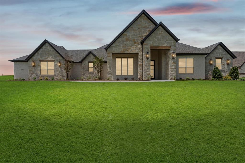 This stunning new construction Catalina floorplan by Couto Homes offers 4 bedrooms, 3 bathrooms, a study, game room, and 3-car garage across 3,435 square feet of thoughtfully designed living space. Wood beams and warm natural finishes bring character to the main living areas, anchored by a dramatic floor-to-ceiling stone gas fireplace with a custom mantel and full arch walkthrough openings throughout. The chef's kitchen features an oversized island with quartz countertop, a Blanco Silgranit sink, custom cabinetry, a dedicated coffee nook, and appliance package including a 5-burner gas cooktop, double wall oven, drawer microwave, and dishwasher — plus a gas stub-out for a future outdoor kitchen. The primary suite impresses with a Dutch vault box ceiling, spa bath complete with a freestanding soaking tub with wall-mount fill, beach-entry frameless glass shower, custom tile surround, and dual vanities with Moen Matte Black fixtures. Secondary baths include custom tile work, decorative niches, and Moen Matte Black finishes. Engineered wood flooring carries throughout all main living areas with 8' interior doors, radiant barrier OSB roof decking, open-cell foam insulation, 14 SEER HVAC with electric heat pump, and a Honeywell WiFi thermostat. Outside, the striking white-beige brick and natural limestone exterior is complemented by stained tongue-and-groove porch ceilings, a matching all-stone mailbox, and a 15,000+ sq ft landscaping package. Don't miss this one — schedule your private showing today!
