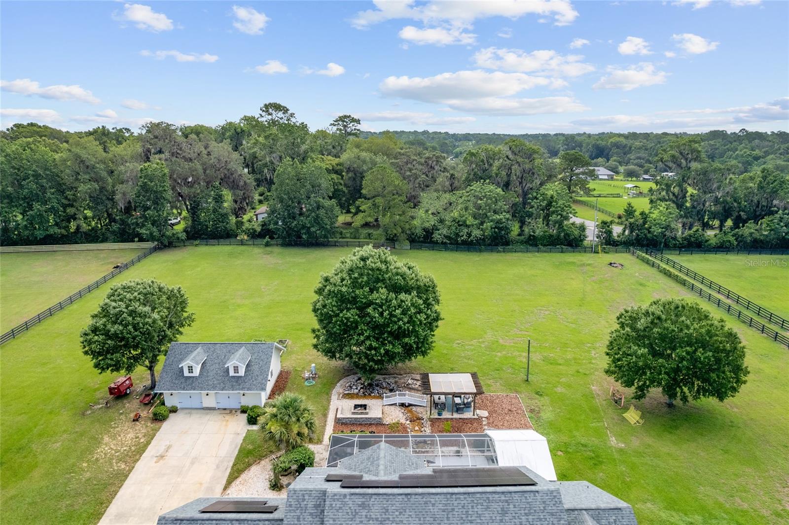 Hold on to your saddles, because this one is truly special! Nestled in the heart of South Ocala’s renowned horse country, this move-in ready equestrian estate in the exclusive community of Bridle Run offers a rare blend of luxury, functionality, and serene rural living. Situated on 4.36 acres with access to private, non-motorized community bridle trails, this property is ideal for equestrian enthusiasts, nature lovers, or anyone seeking refined country living. An automated gated entrance welcomes you to this beautifully maintained 5-bedroom, 3-bathroom POOL home featuring an upstairs theatre room with a mini kitchen and additional attic space—perfect for a media room, home office, or guest suite. Thoughtful upgrades include solar power with a grid-tie system (unused energy is sold back to the grid), electric vehicle/generator-ready garage, fiber optic internet, and a newer water heater and heat pump. The home includes two AC units—one replaced in 2021 and the other original but functioning well with recent service. The interiors feature built-in carpet in the living room and stairs, with propane lines already in place for the saltwater pool, and both indoor and outdoor gas fireplaces. The property is equipped with well and septic systems for added independence and efficiency. Outdoor living is a dream with a resort-style pool area complete with a kitchen and grill setup, a charming pergola, fire pit, generator ready, and a tranquil river waterfall. A detached garage includes a workshop and attic storage, perfect for hobbies or additional space. The grounds also feature a garden, sandbox, and plenty of open space for both your family and horses to enjoy. Bridle Run’s HOA maintains the main entrance and trail system, with a scenic horse trail running directly behind the home. A new school (Winding Oaks Elementary) was just built nearby, adding value and convenience to this already desirable location. Enjoy being less than 10 minutes from the Florida Horse Park and Marjorie Harris Carr Cross Florida Greenway Trails, approximately 15 minutes from Downtown Ocala, and only 25 minutes from the World Equestrian Center. Whether you’re living the equestrian lifestyle or simply looking for peaceful country luxury, this exceptional Bridle Run property is not to be missed. Proudly built by their family and Thoughtfully cared for, this home offers a rare opportunity to own a property with true pride of ownership. Now ready for its next chapter, this home welcomes a new owner to create lasting memories for years to come. *** ASK TO SEE OUR INTERIOR AND EXTERIOR VIDEO TOURS!!! ***