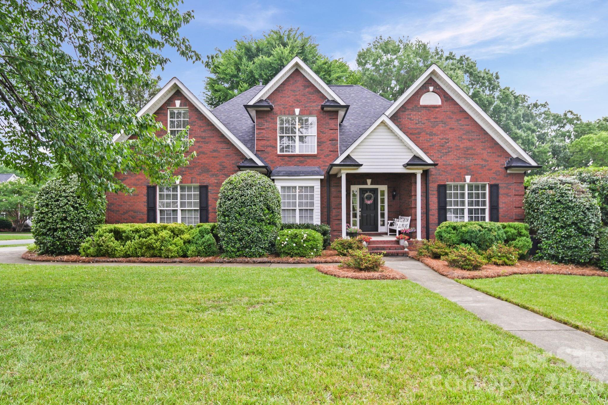 Elegant full-brick home nestled on a little over half-acre lot in an established neighborhood with mature trees and timeless curb appeal. This beautifully maintained property features a side-entry 2-car garage, fully fenced backyard, and a private wooded setting perfect for relaxing or entertaining. Enjoy summer days by the gorgeous inground pool, evenings under the charming café lights, and grilling on the mainenance free back deck. An outdoor storage building provides added convenience for tools, hobbies, or seasonal items. Inside, the open floor plan is filled with natural light and impressive architectural details including a dramatic two-story living room and soaring vaulted ceilings that flow seamlessly into the kitchen. The primary suite is conveniently located on the main level and features a spacious ensuite bath and walk-in closet. Upstairs offers three additional bedrooms and a full bath, providing plenty of space for family, guests, or a home office.A rare combination of privacy, character, and functional living spaces in a sought-after established community.