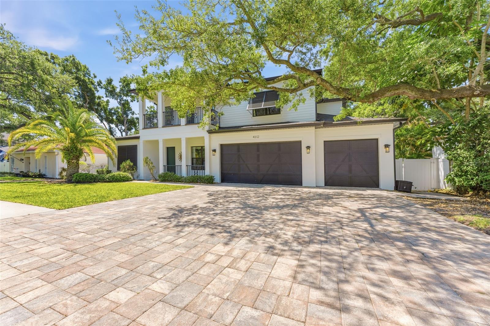 Under contract-accepting backup offers. Set behind a welcoming covered porch, this 5-bedroom, 4.5-bath pool home pairs thoughtful design with a clean, modern sensibility—updated and move-in ready with a new roof (2024), fresh exterior paint (2024), new front and side entry doors (2024), and engineered hardwood flooring throughout the second level (2024).Inside, the layout opens effortlessly, anchored by a main living room with soaring 20+ foot ceilings that bring in natural light and create a striking sense of volume. The kitchen connects seamlessly to this space, centered around an 11-foot island, solid wood cabinetry, and a curated appliance package featuring Fisher & Paykel (including the signature double-drawer dishwasher) and a Viking wine refrigerator. A walk-in pantry adds function, while integrated surround sound elevates both everyday living and entertaining. The home is fully equipped with an ELAN Smart Home System for seamless control of audio and technology throughout.The primary suite is privately positioned on the first floor, adorned with tray ceilings, and a well-composed bath with a freestanding soaking tub, an expansive walk-in shower, and custom closets with built-in cabinetry. A separate first-floor guest suite sits across the home, creating a comfortable and private arrangement for visitors.Upstairs, three additional bedrooms, two full baths, and a large media room provide flexibility for daily living. Custom shelving and built-in surround sound define the space, while direct access to a front-facing balcony adds an unexpected extension.Outdoors, the home transitions into a fully realized entertaining environment. A covered lanai with integrated speakers, television, and a modern fireplace overlooks a travertine-framed pool. Low-maintenance turf keeps the grounds crisp year-round. The outdoor kitchen—complete with grill, Big Green Egg, refrigerator, and ice maker—sits adjacent to a pergola dining area designed for long evenings and easy gatherings.Built with efficiency and durability in mind, the home is Energy Star certified and includes spray foam insulation, in-wall pest control tubing, fabric hurricane shutters, and insulated attic storage.Located within the highly regarded Dale Mabry / Coleman / Plant school district, this is a home that delivers both substance and style—ready to be experienced from day one.