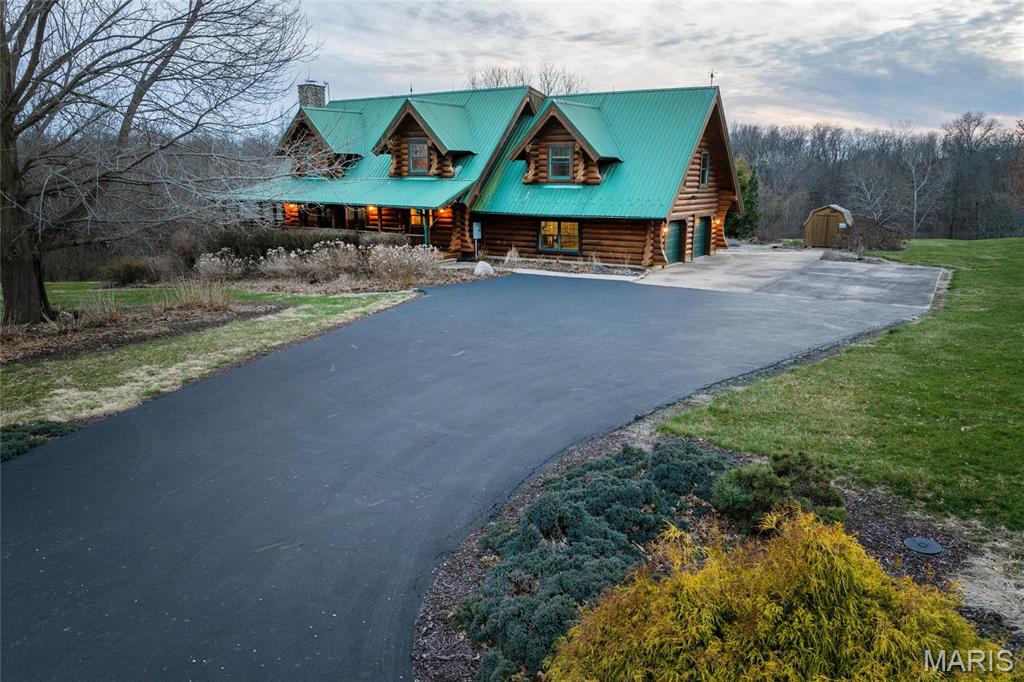 Experience the allure of this exquisite log home nestled on a sprawling 11-acre estate. The lodge boasts a 2-story living room adorned with a magnificent river stone fireplace and a loft area that overlooks the space. The primary suite offers a sanctuary of comfort and style. The custom kitchen boasts stainless steel appliances and stone countertops along with optimal space to create enticing meals. A fully finished walk-out basement with a living space, rec room, and an additional non-confirming bedroom for added functionality. Immerse yourself in the tranquility of the surroundings, accentuated by landscaped gardens and a serene creek meanders through the property. Nature enthusiasts will delight in the opportunity for hunting, target shooting, and wildlife observation on this pristine estate. Tuck everything away in the oversized 2-car attached garage. Embrace the ultimate retreat into nature and find solace in the serenity of this exceptional log home.