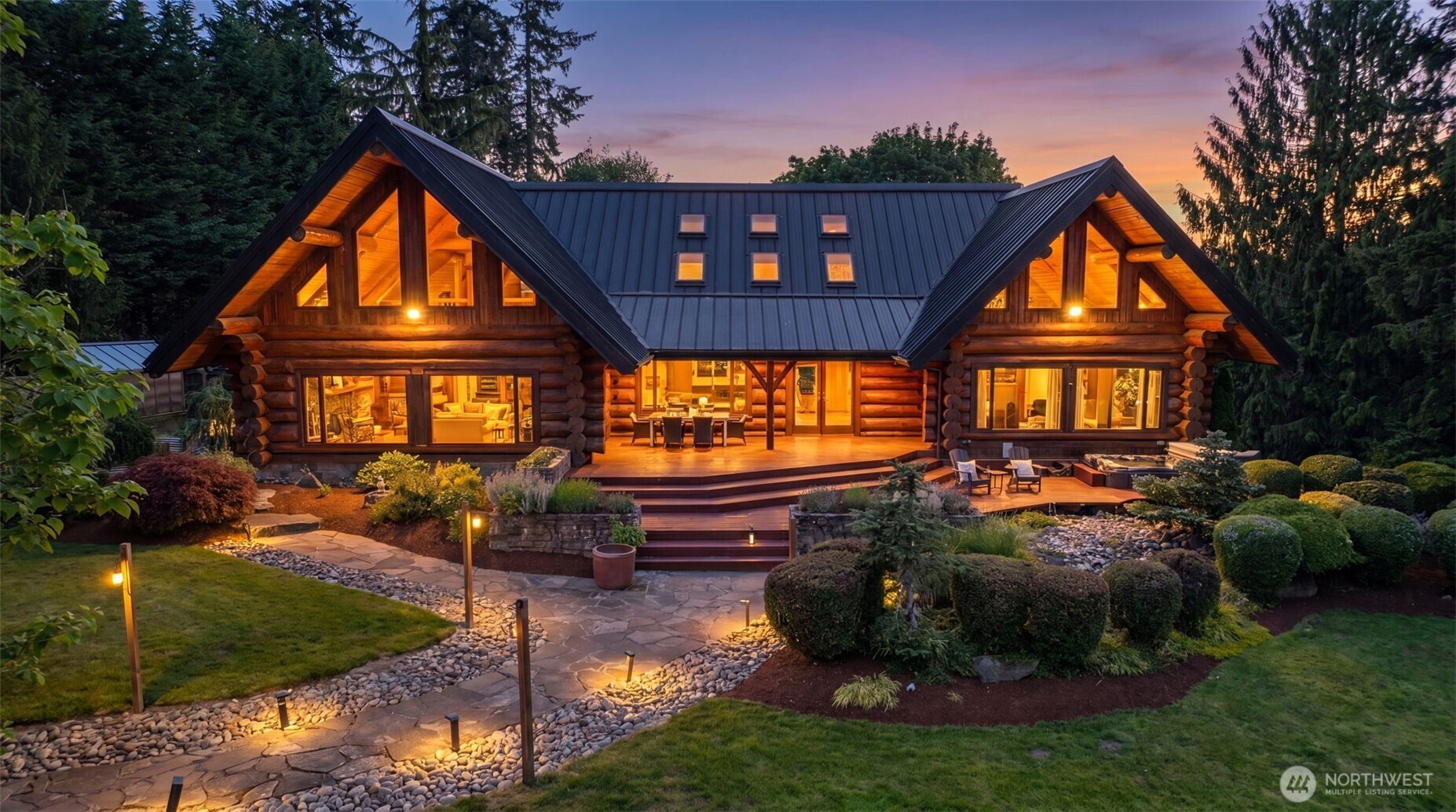 Tucked away on nearly 10 acres of beautifully maintained grounds, this extraordinary log home offers a rare blend of timeless craftsmanship, natural beauty, and modern comfort. Rich wood finishes, soaring 25-foot ceilings, and walls of windows frame peaceful territorial views, while the dramatic great room is anchored by a handsome stone gas fireplace designed for both everyday living and entertaining.  The chef’s kitchen features an oversized honed granite island, stainless steel appliances, abundant workspace, and seamless flow into the dining and living areas. Indoor-outdoor living comes naturally with expansive entertaining spaces, a covered area for year-round enjoyment, and an 8-person hot tub surrounded by the beauty of the property.  The main-level primary suite offers the convenience of main-floor living, while two additional bedrooms upstairs provide flexibility. The lower level includes two non-conforming rooms ideal for hobbies, office space, guests, or additional living needs.  Recent updates include new flooring, appliances, water heater, whole-home generator, water filtration system, well pump, garden installation, and new back and side decks. Outside, you’ll find fruit trees, a lovely greenhouse and raised garden beds, RV parking, a koi pond and sprawling acreage, creating a true Pacific Northwest retreat. A one-of-a-kind property offering privacy, livability, and room to explore.