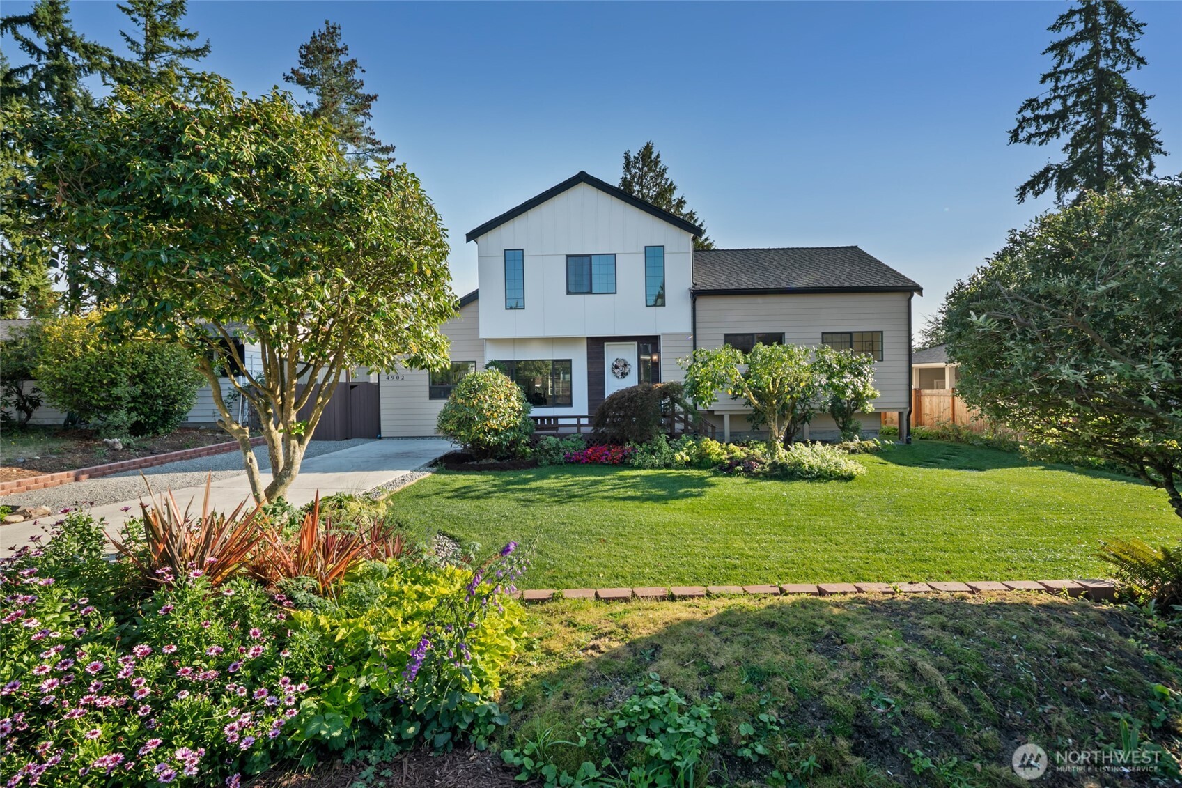 Be the envy of the neighborhood in this fully rebuilt contemporary 2,868-sf/4-Bed/2.5 Bath home framed by gorgeous, thoughtful landscape. Open concept w/9’+ ceilings on both levels, windows & skylights galore create bright inviting spaces. 8’ solid doors, Mini-split in every room, heated bath flrs, solar panels, EV charger & 50-year roof. Sleek gourmet kitchen w/gas stove, butler’s pantry & large island opens to the huge Dining/Living area. A few steps up to 3 beds & Full Bath. Entire top level is the indulgent primary w/FP, huge WIC & spa inspired 5-piece bath. LL-Office, Rec & Laundry rms. Large composite deck, big yard w/lush lawn & pergola. Plenty of parking. Unbeatable location w/EZ access to I-5, mins from the new Light Rail Station.