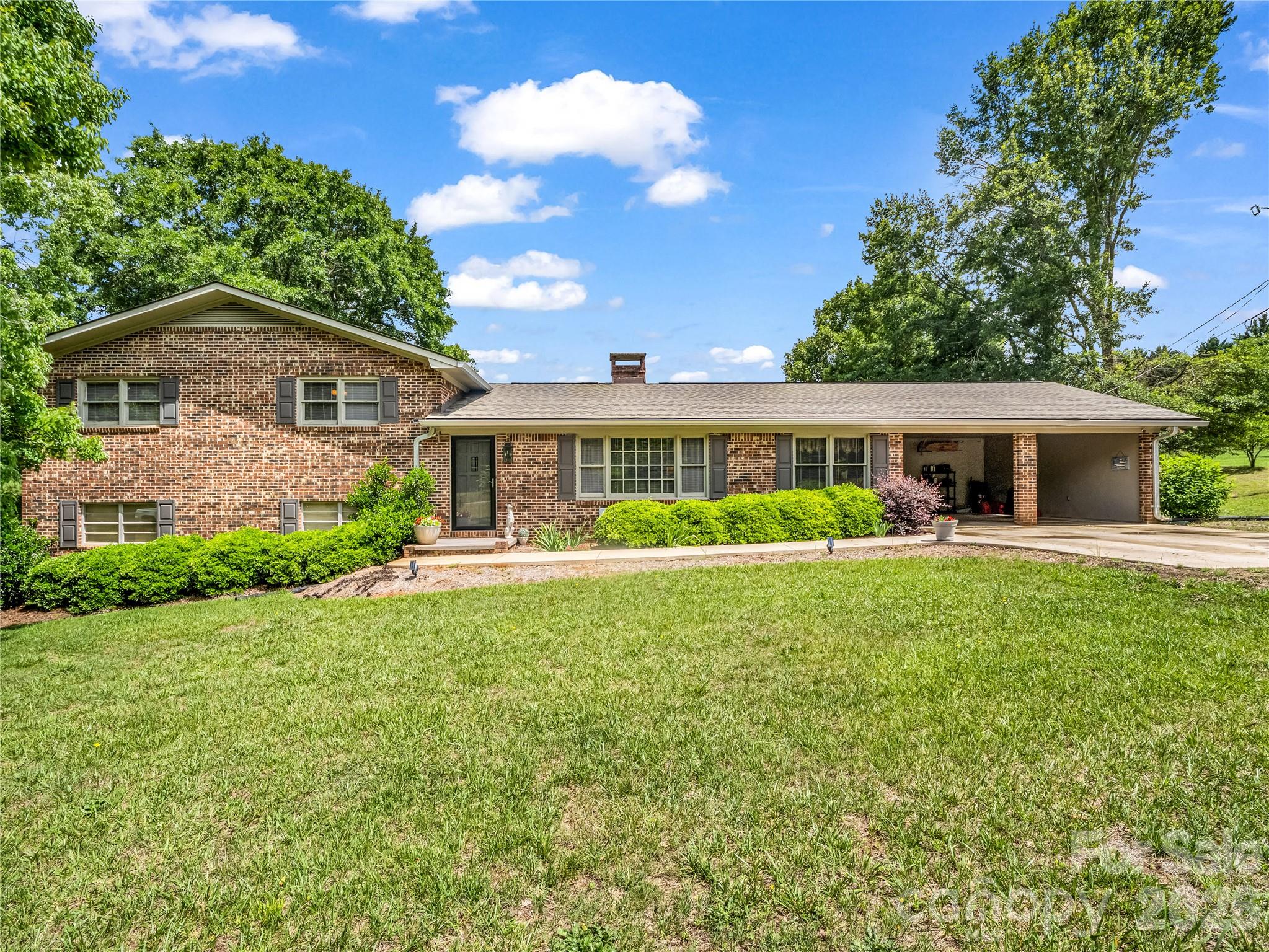 Nestled on approximately 7 picturesque acres in Polk, this classic brick ranch estate offers an exceptional blend of privacy, functionality, and refined country living. Surrounded by mature trees, open pasture, and peaceful wooded acreage, the property delivers the tranquility and seclusion discerning buyers seek while remaining conveniently located in the heart of Green Creek, Tryon area.The main residence features 3 bedrooms and 2 full bathrooms on the upper level of a split-level home. Designed for both comfortable everyday living and effortless entertaining, the main level showcases an open kitchen, a private office, pantry, or flexible formal dining room. Inviting living areas are filled with timeless character and natural light, creating a warm and welcoming atmosphere throughout. The laundry area is conveniently located in the basement. Thoughtful recent improvements include new appliances & hot water heater- less than 7 months old, a beautifully remodeled hall bathroom, and a new roof with stainless steel gutters-completed within the last three years. Anattached two-car carport and additional concrete parking provide both convenience and functionality. The expansive acreage offers endless possibilities for an equestrian retreat, private homestead, hobby farm, or multi-generational estate. With a rare combination of usable land and natural beauty, this property creates a true retreat-like atmosphere just minutes from the charm, dining, and culture of The Tryon International Equestrian Center. Adding exceptional value is the separate garage apartment located at 90 McEntire Rd adjacent to the main residence. This versatile guest quarters includes a two-car garage, flex room. and bathroom on the main level, with upstairs living space featuring 1 bedroom and 1 full bathroom. Ideal for guests, extended family, a private office, caretaker accommodations, or continued rental income potential. The garage apartment is currently tenant-occupied through at least October, and the tenant has expressed interest in remaining with the new owner, offering an immediate income-producing opportunity from day one. The estate is comprised of three separately deeded parcels offering flexibility and future potential: 2.41 acres with the main residence, 1.77 acres with the garage apartment, and 2.93 acres of open field/pasture behind both structures. Offering acreage privacy, multiple living spaces, and investment potential in one of Western North Carolina's most sought-after small-town settings, this unique property presents a rare opportunity to enjoy elevated country living in beautiful Tryon.