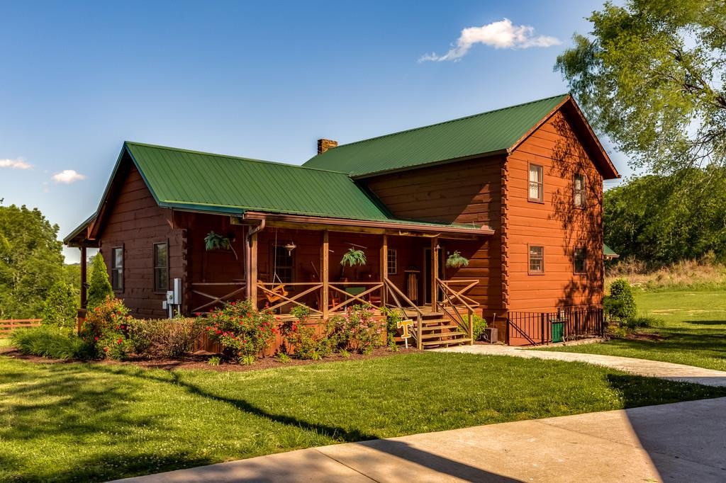 Absolute DREAM HOME!Welcome to this stunning log cabin home nestled on 82.74 breathtaking acres, offering privacy, charm, and endless possibilities. This one-of-a-kind property is perfectly suited for those seeking luxury country living with room to roam.The main log cabin features 4 spacious bedrooms and 3.5 baths, highlighted by a gorgeous stone fireplace, granite countertops, and beautiful hardwood and tile floors throughout. Designed for comfort and entertaining, the home boasts three covered porches, perfect for enjoying peaceful views and outdoor living year-round.Equestrian and hobby enthusiasts will love the horse barn, while the property also includes two garages, one of which offers a guest room with a private bath—ideal for visitors, extended family, or a private retreat.This exceptional property combines rustic elegance with modern convenience, all set against a backdrop of rolling acreage and natural beauty. A rare opportunity to own a truly special retreat—this is country living at its finest.