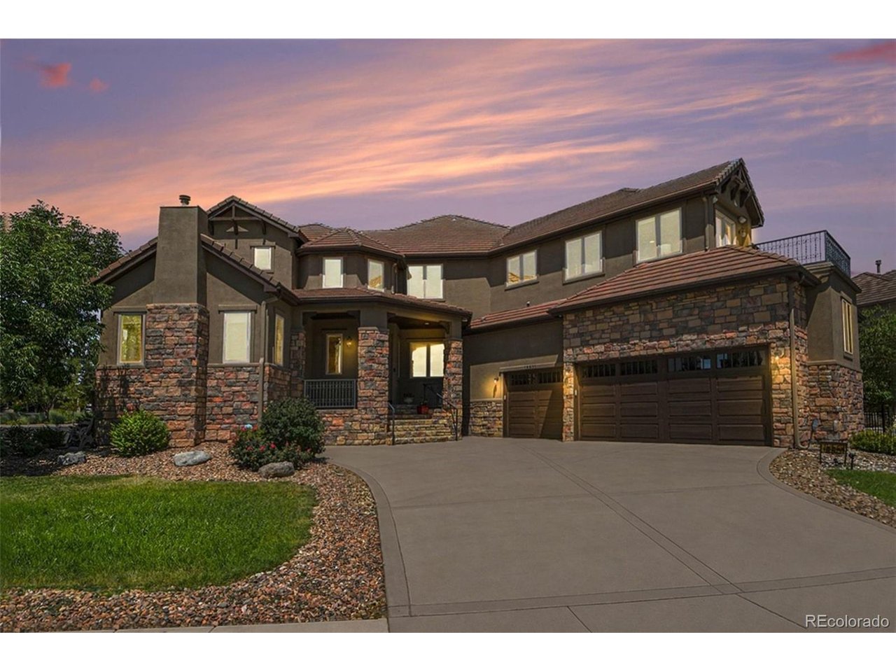 A Parade of Homes showcase on a premier corner cul-de-sac lot in The Gallery, Reunion's gated and most exclusive enclave, with picturesque views over Buffalo Run Golf Course.The first impression belongs to the architecture: a timeless stone-and-stucco exterior rising above manicured landscaping, with the presence only a corner setting allows. Inside, the dramatic two-story great room features a floor-to-ceiling stone fireplace anchoring walls of glass that flood the home with Colorado light and frame the scenery beyond.The gourmet kitchen was designed to move effortlessly between quiet mornings and full-house entertaining: an oversized center island, extensive custom cabinetry, a sunlit breakfast nook, and a well-appointed butler's pantry linking the kitchen to the home's formal spaces.Upstairs, the primary suite is a genuine retreat with a private balcony, a spa-inspired bath with decorative tile and dual vanities, and a walk-in closet of true scale. Three additional bedrooms each enjoy a private ensuite bath, while a versatile bonus room adapts easily as a playroom, or second office.The professionally finished basement lives like a residence of its own, offering a generous recreation and media area, wet bar, home office, and two more bedrooms, ideal for extended family, guests, or multigenerational living.Outside, the landscaped backyard and expansive patio were made for Colorado evenings, whether outdoor dining, entertaining, or simply watching the light change over the surrounding terrain. An oversized three-car garage adds EV charging and generous built-in storage.For buyers relocating from out of state: Reunion is one of metro Denver's premier master-planned communities, and The Gallery is its most coveted enclave. Homes of this pedigree rarely reach the market, showcase craftsmanship, an irreplaceable setting, and the Colorado lifestyle buyers seek.