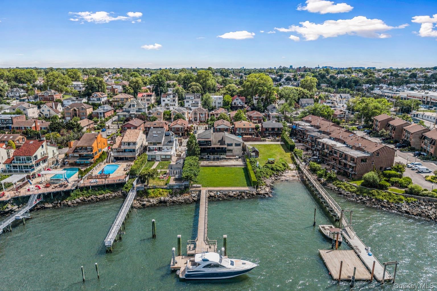 Set behind private gates on an oversized waterfront parcel with 700 feet deep to the water to build your own boat dock, this extraordinary contemporary estate is a rare offering where architectural sophistication and resort-style living converge. Showcasing panoramic water views from every level, this one-of-a-kind residence delivers an unparalleled lifestyle of luxury, privacy, and tranquility.Designed with exceptional attention to detail, the home features 3 spacious bedrooms and 3.5 designer bathrooms, complemented by expansive entertaining spaces curated for both intimate gatherings and grand-scale hosting. The third level offers three beautifully appointed bedrooms, including one with a loft currently configured as a private fitness retreat. Occupying its own exclusive fourth floor, the lavish primary suite is a sanctuary unto itself, complete with a private waterfront balcony with amazing views of The Throgs Neck Bridge, oversized custom dressing room, and a spa-inspired marble bath with Jacuzzi tub overlooking the water. The residence seamlessly blends indoor and outdoor living. A stunning enclosed glass lounge with a sophisticated wet bar opens to an extraordinary waterfront patio featuring a built-in hot tub spa, creating the ultimate setting for entertaining against a breathtaking backdrop. Multiple terraces and decks throughout the property capture spectacular sunsets and endless water views. At the heart of the home is a chef’s kitchen designed to impress, featuring elegant Quartz countertops, premium stainless steel appliances, a center island, and a sunlit dining area. Bespoke finishes and artisan-crafted details are showcased throughout, including etched glass door inserts, custom storage solutions, cedar closets, and two working fireplaces that add warmth and character to the home’s refined aesthetic. Additional highlights include a third-floor laundry room, attached two-car garage, and ample parking for six or more vehicles. Offered fully furnished, this diamond-condition estate embodies effortless luxury — where every day feels like a private waterfront escape. A truly exceptional offering for the most discerning buyer.