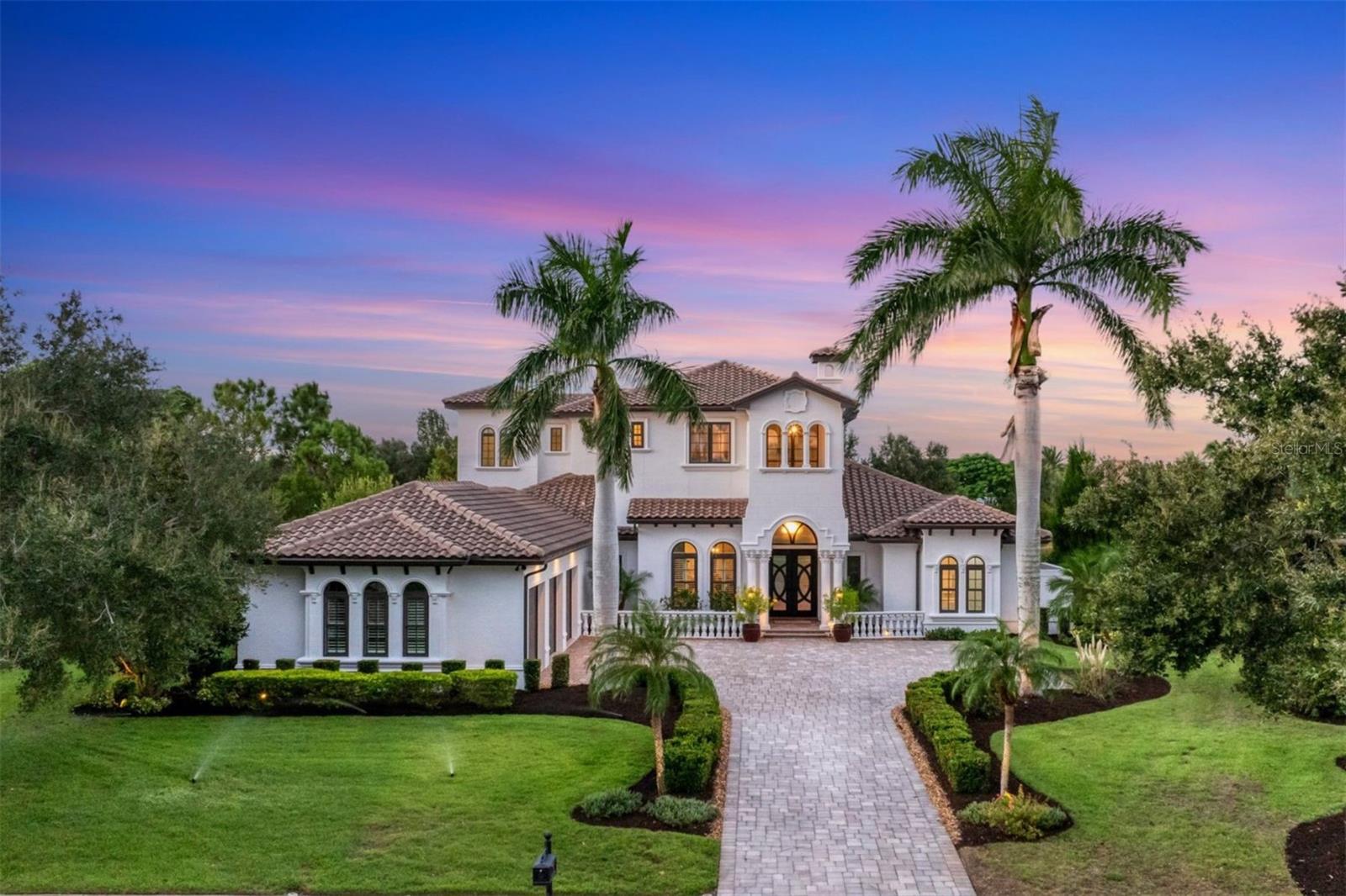 Under contract-accepting backup offers. Prestigious Lake Club estate on rare oversized water lot! Set in the original section of The Lake Club on sought-after Clearlake Avenue, this custom Paradise Homes estate offers a blend of elegance and timeless Florida living. With over 4,000 square feet of thoughtfully designed space, every detail has been curated for everyday comfort. A freshly painted exterior, lush landscaping, and views of the park welcome you from the front, while expansive water views unfold in the back. Go through iron double doors into the soaring two-story foyer, where natural light and architectural details set the tone with teak hardwood floors, crown moldings, coffered ceilings, and plantation shutters throughout. The formal living room is an entertainer’s dream, featuring a stacked-stone electric fireplace, newly added dry bar with large wine cooler, custom built-in cabinetry and pocketing hurricane-impact sliders that open to the lanai. A formal dining room sits just off the entry for special occasions. The recently refreshed chef’s kitchen (2022) impresses with quartzite countertops, Viking double ovens and convection microwave, a 36-inch Fulgor Milano Pro Range cooktop and refrigerator, new Bosch dishwasher (2025), large island with prep sink, stylish pendant lighting and an eat-in nook. The first-floor primary suite is a private retreat with a sitting area overlooking the pool and custom walk-in closets. The renovated primary spa-inspired bath (2024) features dual sinks, soaking tub, and large rainfall shower. Guests will appreciate their choice of two first-level guest bedrooms with designated guest bath, while the upstairs bonus room offers endless versatility, such as media room, gym or lounge, complete with a wet bar, beverage cooler, 7.1 surround wiring, and balcony overlooking the water. A fourth bedroom and full bath complete the upper level. Outdoor living shines with a heated saltwater pool with sun shelf and spa, new screened pool cage (2025), and updated equipment including a new pump, interchlorinator, plumbing and valves. The completely remodeled outdoor kitchen with high-density polyethylene cabinetry is equipped with a Hestan sear grill and rotisserie, oversized 42-inch Falmec hood and Zephyr beverage cooler. Multiple covered areas of the paver lanai provide a setting for dining alfresco or relaxing by the water. This home also offers smart home automation allowing you to control the pool, spa, and lighting from your phone. The huge garage (over 1,000 square feet) with epoxy floors is wired for an EV charging station, while two tankless water heaters, hurricane-impact windows and doors, and updated irrigation system add convenience and peace of mind. This rare, oversized waterfront lot, paired with Paradise Homes’ Florida Certified Green build quality, makes it a standout. In The Lake Club is an impressive 20,000-square-foot Grande Clubhouse, a hub of luxury amenities. Enjoy two pools, including a zero-entry pool with splash park, ideal for family fun. Indulge in poolside dining and unwind at the spa and fitness center offering guided workout classes, massages and facials by on-staff aestheticians. Sports enthusiasts will appreciate the tennis and pickleball courts with racquet pros available. Experience a vibrant social scene with a calendar filled with events. Don’t miss the opportunity to experience luxurious lakefront living at its finest in The Lake Club, where luxury, lifestyle and location converge.