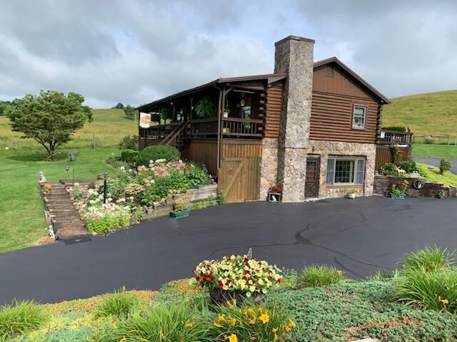 HUGE PRICE REDUCTION! Come feel the love and warmth in this custom built log home conveniently located just off I81 between Glade Springs and Chilhowie, VA!  This cozy 2 bedroom 1 bath home offers custom features such as hardwood floors throughout, a floor to ceiling wood burning rock fireplace and a beautiful vaulted ceiling with wooden beams!  The living room and kitchen has an open floor plan to make it great for entertaining.  The home has a wrap around porch to enjoy the morning coffee or a sweet tea in the evenings!  Or sit in the nice gazebo in the back yard and gaze at the stars!  Updates include replacement vinyl windows and a metal roof.  A partially finished basement offers a great family room with a cute pot belly stove that provides extra wood burning heat in the winter time.  The unfinished storage area in the basement could easily be finished for an extra bedroom and bath, it's already plumbed just waiting to be finished.  Come see and make this your next home!