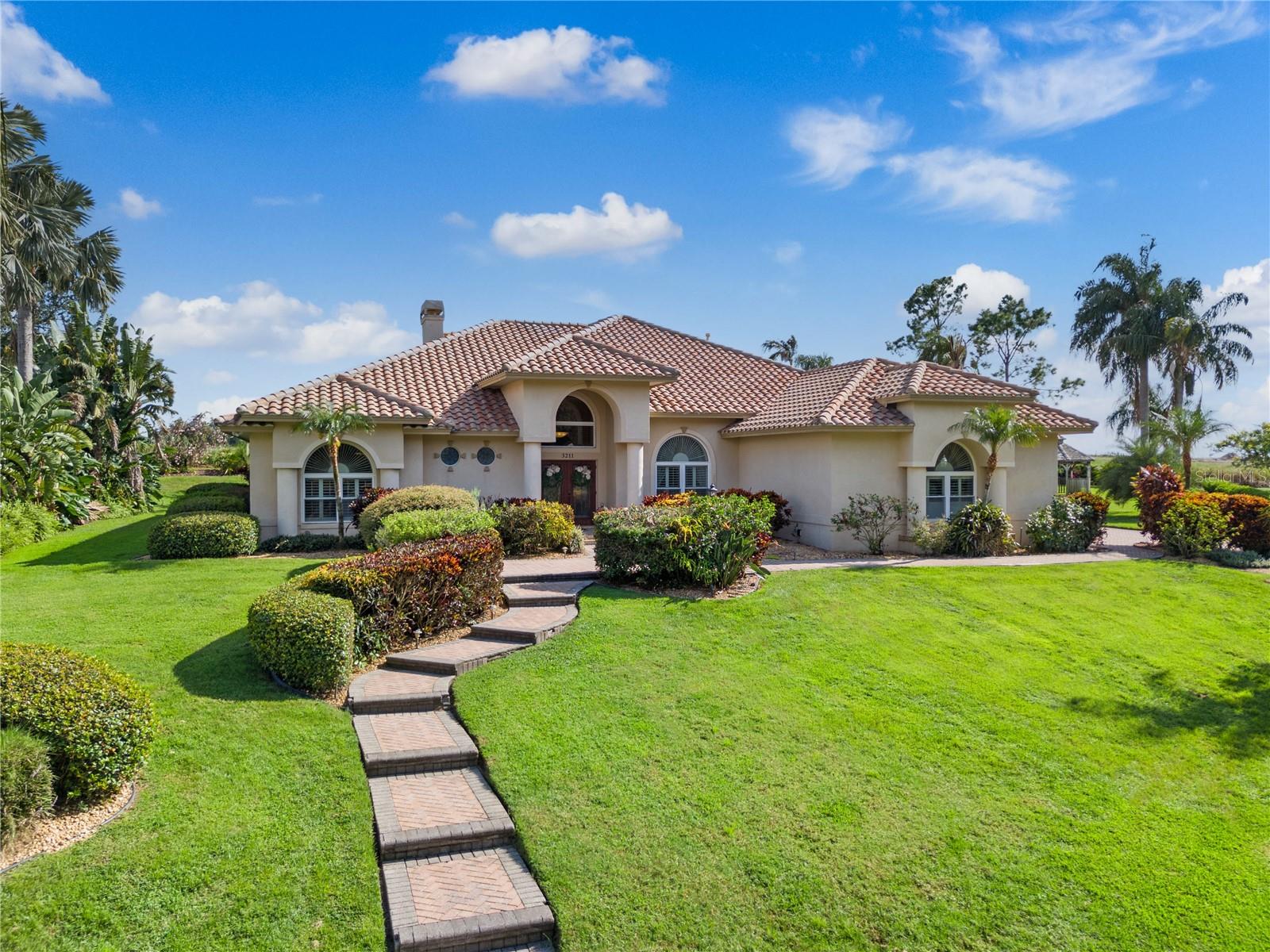 Executive-level gated pool home located in the exclusive community of Heron Cay! Welcome to this intimate enclave of just 24 homes where you'll discover this highly-upgraded property with a level of finishes, details and amenities most homes do not possess. With four bedrooms, three and half baths, 3400 sqft of living and an oversized 0.66 acre lot, this is the perfect blend of architectural detail, privacy, and resort-style living.A stately façade, manicured landscaping, and mature palms create strong curb appeal. Inside, rich bamboo floors, Italian travertine, and a thoughtful split layout enhance both daily comfort and entertaining. The formal living room features a travertine fireplace, while the open family room offers abundant natural light, built-in AV storage, and seamless access to outdoor living.The chef’s kitchen is a standout with exotic granite countertops, a leathered-granite island, Sub-Zero 120-bottle wine refrigerator, professional stainless appliances, natural gas range, hidden butler’s pantry, and dedicated coffee station. A nearby entertainer’s bar is perfect for cocktails by the pool.The primary suite is a private retreat with a spa-inspired bath featuring an oversized walk-in shower with body sprayers, separate steam shower, granite vanity with makeup area, and a massive walk-in closet. Two guest suites offer private baths and walk-in closets, while the fourth bedroom provides flexibility for a gym, office, or media space.Outdoor living shines with hammered marble decking, a heated pool and spa, covered and open lounging areas, lush landscaping, and a pavered sitting area offering total privacy. Additional upgrades include a whole-house generator, water-filtration system, impact-rated doors, insulated windows, plantation shutters, tile roof, irrigation well, and a 3-car garage with extensive storage.Heron Cay residents enjoy gated privacy and direct access to Lake Eloise, connecting to 20+ lakes for boating, skiing, dining, and nightly LEGOLAND fireworks. Ideally located between Tampa and Orlando, this home offers quick access to shopping, dining, medical care, and Winter Haven’s vibrant lifestyle.A rare opportunity to own a luxury custom home in one of Winter Haven’s most prestigious communities.