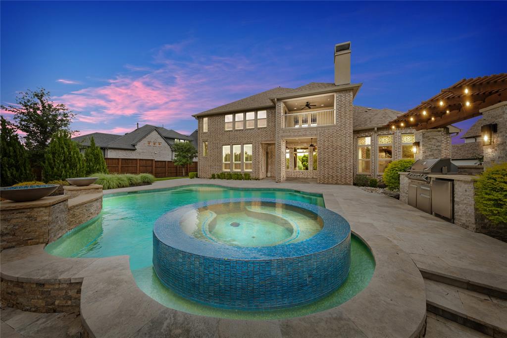 Set on a rare .63-acre lot, this meticulously maintained Prosper estate delivers exceptional scale, craftsmanship and resort-style living. Soaring ceilings, abundant natural light, custom wood flooring, bespoke cabinetry and designer finishes create an elevated interior throughout. The open kitchen and family room flow effortlessly for entertaining, while a first-floor media room and luxurious primary suite with spa-inspired bath add everyday comfort. Outdoors, enjoy a resort-style pool, grilling station, expansive private yard, greenbelt views and upstairs balcony. A 4-car garage completes this exceptional offering in Prosper ISD, zoned to Walnut Grove High School.