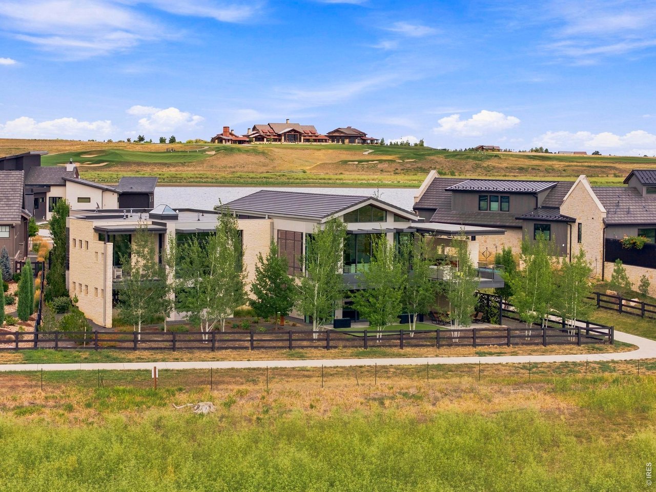 Stunning, one-of-a-kind modern luxury retreat perfectly positioned on the peninsula in Heron Lakes at TPC Colorado, where dramatic floor-to-ceiling windows frame breathtaking panoramic views. Meticulously designed with exceptional craftsmanship and timeless finishes, this home features zero-threshold living, imported Spanish porcelain flooring throughout, and a sleek, sophisticated aesthetic. The thoughtfully designed main level offers two bedrooms, a private den, a cozy breakfast nook, spacious living and dining areas, and a chef's kitchen equipped with premium Gaggenau appliances, induction range and a Fisher & Paykel CoolDrawer. Additional highlights include a partially heated driveway and a private elevator providing effortless access to the walkout lower level. Designed for both entertaining and everyday luxury, the lower level features a golf simulator, wet bar, expansive family room, two additional bedroom suites, a private office, and a powder bath, seamlessly extending to the outdoor living spaces. TPC Colorado offers resort-style living with a golf course, clubhouse, second restaurant, pool, state-of-the-art-gym, lakes and walking trails.