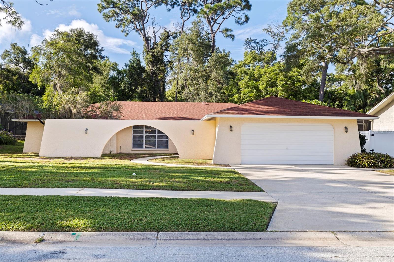 Welcome to Indian Trails, one of Palm Harbor’s most desirable and welcoming neighborhoods, where location, lifestyle, and value come together. Set on an oversized .40-acre lot with a peaceful conservation backdrop, this inviting pool home offers privacy, space, and an exceptional opportunity to make it your own. The home has been well maintained, and the interior is ready for its new owner to refresh the finishes, colors, and spaces to reflect their personal style and vision. A thoughtful split-bedroom floor plan provides both functionality and flexibility, with views of the pool from most rooms. The family room is anchored by a stone-accented wood-burning fireplace, while the living room and dining combination creates an inviting space for everyday living and entertaining. Two bedrooms share a convenient Jack & Jill bathroom, while a guest half bath adds functionality. The fourth bedroom offers direct access to the primary bedroom, making it ideal as a nursery, home office, private sitting room, or guest space. A spacious two-car garage provides ample room for vehicles, storage, and hobbies. Major updates include a NEW ROOF BEING INSTALLED, HVAC replaced in 2025, and Hot Water Heater replaced in 2026. Located in Flood Zone X with low HOA fees, this home offers exceptional value in a highly sought-after Palm Harbor location. The school zone includes Sutherland Elementary, Palm Harbor Middle School, and Palm Harbor High School, conveniently located within walking and biking distance. Indian Trails is an exceptionally friendly neighborhood known for its informal community activities, with neighbors coming together throughout the year and visitors traveling from near and far to enjoy the neighborhood’s famous annual holiday light displays. Just a couple of blocks from the Pinellas Trail and approximately six miles from Honeymoon Island and its award-winning beaches, you’ll also enjoy convenient access to shopping, dining, parks, and everyday amenities throughout upper Pinellas County. Tampa International Airport is approximately 16 miles away, making travel convenient while still allowing you to enjoy the relaxed charm of Palm Harbor. This is an opportunity to take a home with an excellent location, generous lot, pool, desirable floor plan, important recent mechanical updates and create something truly your own. Enjoy the self-directed 3D tour!