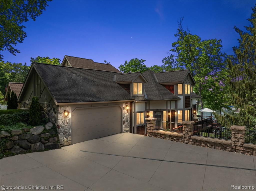 Experience luxurious lakefront living on All-Sports White Lake. From breathtaking year-round sunsets to impeccable custom finishes, every detail has been thoughtfully designed and meticulously maintained. Grand two-story foyer featuring elegant travertine flooring setting the tone for the craftsmanship found throughout. The chef’s kitchen is a culinary dream, equipped w/ premium Viking appliances including a 6-burner range, double ovens, built-in refrigerator, and commercial-grade hood and custom cabinetry. Entertain in the formal dining room or relax in the inviting living room w/ panoramic lake views, a cozy FP, and French doors leading to the expansive wraparound composite deck offers the ultimate setting for outdoor entertaining. Main level office/optional bedroom, plus a custom travertine bath w/ new fixtures, copper sink, and rich travertine countertops, add flexibility and sophistication. First floor laundry room features travertine flooring, Chabert Duvall cabinetry and new LG front-load washer/dryer combo. Upstairs, European white oak flooring leads you to a truly remarkable primary master suite with custom fir beams, cathedral ceilings, built-in custom cabinets, bay window, dual custom WIC and limestone trimmed gas FP. The luxurious spa-style ensuite boasts gorgeous cathedral ceilings, double vanity, heated floors, Italian porcelain tile, curb-less walk-in shower, Brizo fixtures, freestanding tub, and Toto fixtures. Two spacious bedrooms and fully remodeled bathroom complete this level. Finished walkout LL features a full kitchen, guest bedroom, remodeled full bath, comfortable family room opening to show stopping multi-level Pennsylvania bluestone patio w/ custom spiral staircase. Professionally landscaped w/over $500k in custom retaining walls, terraced gardens, mature plantings, and lighting making the outdoor space as stunning as the interior.  Additional highlights include newer HVAC, freshly stained cedar shake siding, and updated exterior paint.