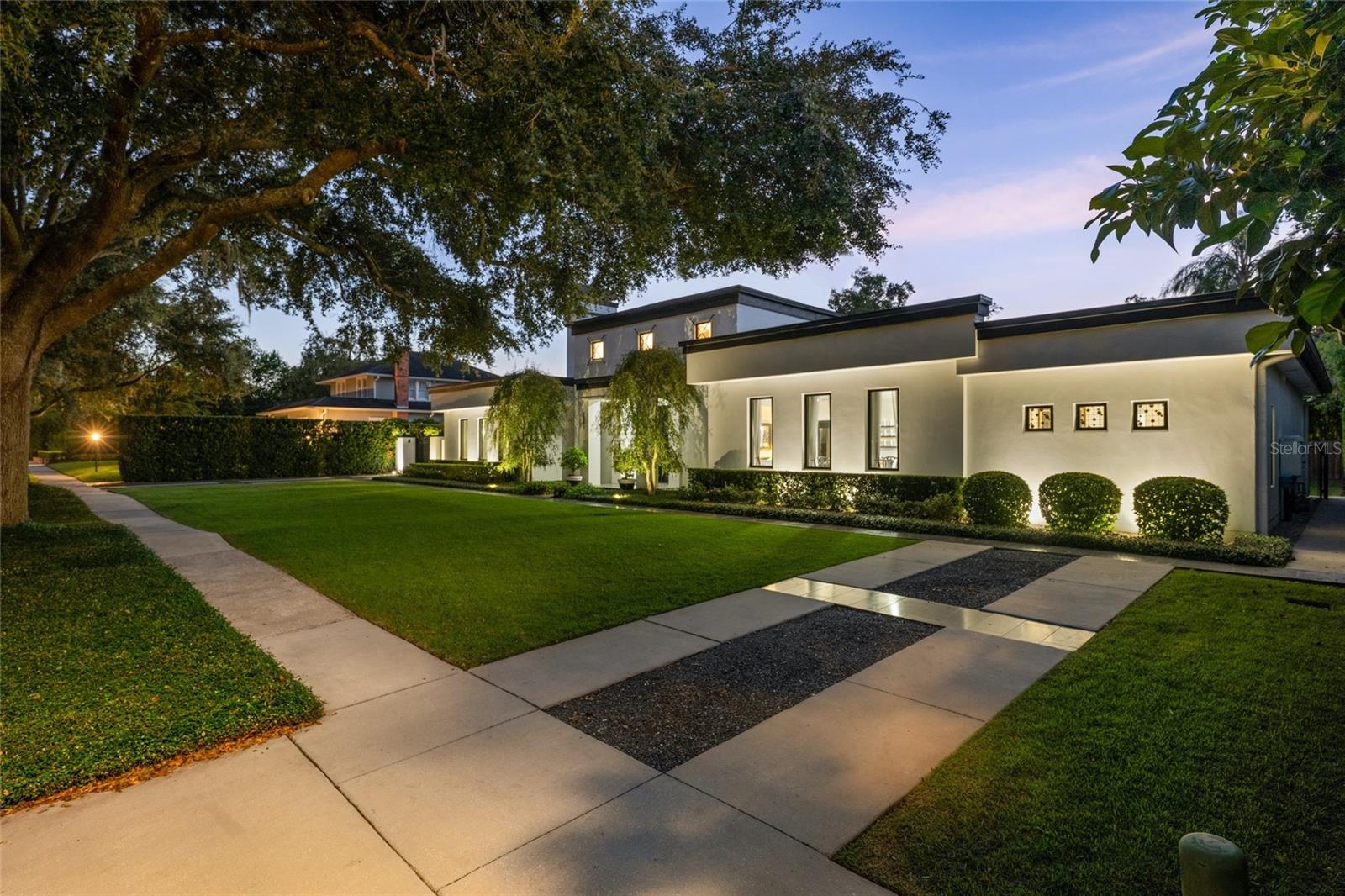 Just steps from the charm and energy of Park Avenue, this exceptional Winter Park residence was completely rebuilt in 2018 by renowned custom builder Posada Homes, member of the elite Master Custom Builders Council. Offering a rare blend of modern design, crisp architectural lines, and timeless elegance, on an expansive 0.39-acre lot along one of Winter Park's most picturesque tree-lined streets. The home immediately captivates with its refined architecture and beautifully manicured grounds. Inside, sunlight streams through expansive windows, illuminating hardwood flooring, intricate millwork, and thoughtfully curated finishes that reflect the craftsmanship of a true custom build. Just off the foyer, a hidden wine room provides a sophisticated surprise, perfect for those who love to entertain. At the center of the home is the chef's kitchen designed for both beauty and functionality. Outfitted with premium Thermador appliances, sleek quartz countertops, a generous center island, and custom cabinetry, the kitchen flows effortlessly into the expansive great room where high ceilings, designer lighting, and elegant architectural details create an atmosphere that is both inviting and refined. Tucked away for privacy, the primary suite is positioned just off a luxurious family room featuring custom built-ins and a gas fireplace. The primary suite itself is a true sanctuary, complete with a sitting area, private coffee bar, and a spa-inspired bath featuring dual vanities, a soaking tub, and an oversized walk-in shower. Rarely found in Winter Park, all bedrooms are conveniently located on one level, including two primary suites. The home offers seamless livability without sacrificing architectural interest or sophistication. Upstairs, a private office, half bath, and bonus room provide the perfect space for work, media, recreation, or relaxation. Outdoors, the home transforms into a private resort-style retreat. A covered lanai overlooks the sparkling pool and expansive grounds, creating the ideal setting for entertaining or quiet evenings at home. Adding even more flexibility, a 252-square-foot detached studio currently functions as a gym but could easily become a summer kitchen cabana, guest retreat, or art studio. Located within walking distance of Park Avenue's boutiques, restaurants, and cafés, and just moments from Rollins College and the Winter Park Chain of Lakes, this residence embodies luxury living at its finest. Don't miss this rare opportunity to own one of Winter Park's most outstanding homes.