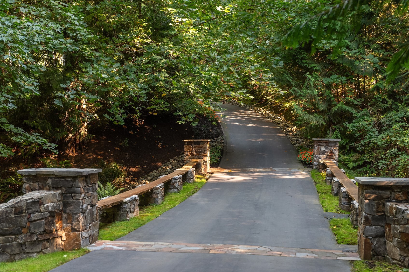 Tree-lined driveway with stone entry pillars