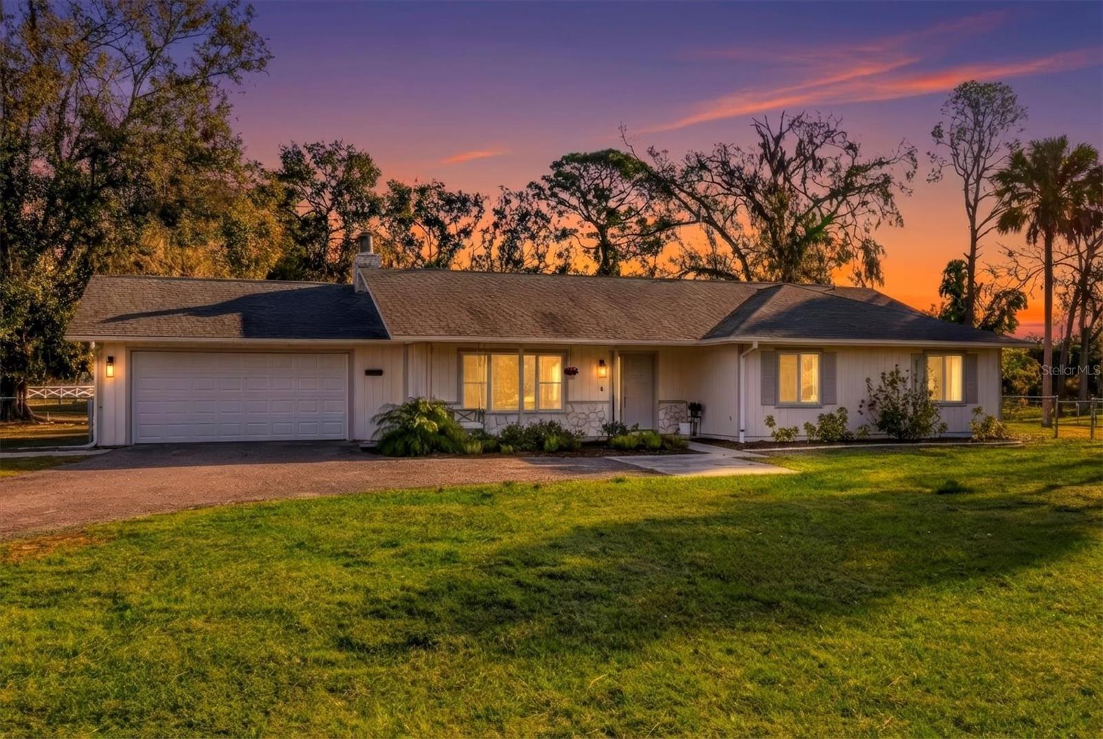 Welcome home to this beautifully updated, move-in-ready ranch set on a picturesque 1-acre lot framed by mature trees, wide-open green space, and tranquil surroundings. From the moment you arrive, the long driveway and peaceful setting create a private, country-style feel with everyday convenience. Located off 44th Avenue E on a quiet dead-end road, the home provides seamless access to Lakewood Ranch and offers peaceful pond views from the front porch for a serene first impression.Inside, a bright, open-concept living space features soaring vaulted ceilings with exposed wood beams, abundant natural light, and warm wood-tone luxury vinyl flooring throughout. The spacious living room is anchored by a stunning stone fireplace, perfect for cozy evenings, and flows effortlessly into the dining area and kitchen. The kitchen is highlighted by a generous 9' x 5' island, offering ample space for entertaining and everyday living.Many of the home’s windows have been upgraded to impact windows, including the sliding glass doors leading to the back patio. The newly updated primary bathroom adds to the home’s move-in-ready appeal.Step outside to enjoy the peaceful setting and multiple outdoor living spaces, including a covered pergola patio ideal for relaxing or dining outdoors. The fully fenced backyard and mature landscaping provide privacy and functionality, while the expansive property offers ample room for outdoor living, gardening, or recreation. Additional features include a detached shed for storage and an attached two-car garage.Offering space, privacy, and timeless appeal, this turnkey property is a rare opportunity to enjoy stylish country living on a full acre of land—quietly tucked away, yet conveniently close to modern amenities and Lakewood Ranch.