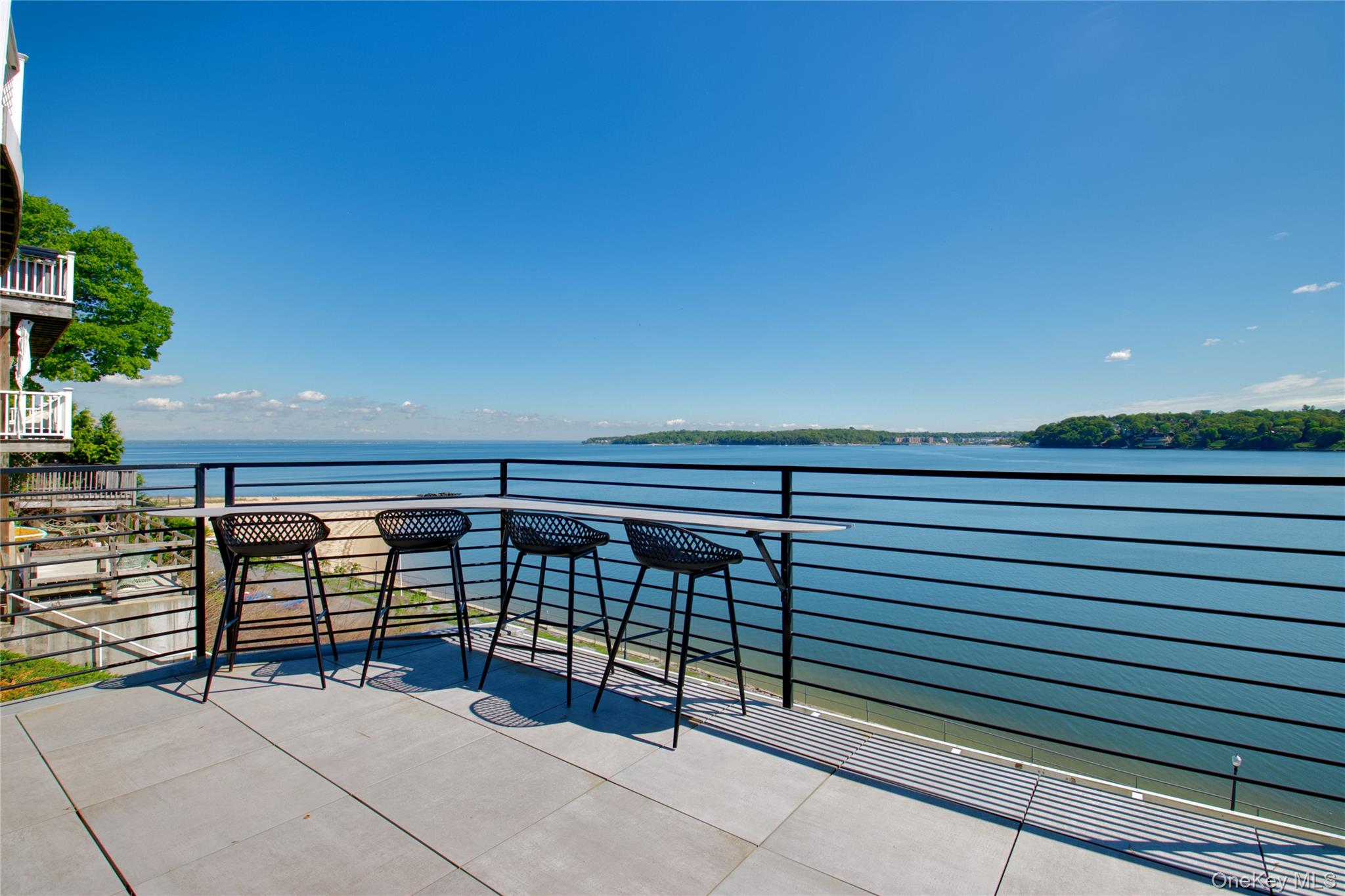New construction modern waterfront residence perched on a bluff in Port Washington with panoramic water views.Completed in December 2024, this award-winning cliffside residence designed by renowned architect Stuart Narofsky offers breathtaking water views from nearly every room.This sophisticated home features 2 bedrooms and 3.5 bathrooms, highlighted by dramatic floor-to-ceiling windows that flood the interior with natural light while framing the surrounding water and coastline. Both bedrooms enjoy water views, with the upper-level suite offering a private balcony, spacious walk-in closet, and luxurious en-suite bathroom.Designed for both comfort and efficiency, the home includes radiant heated floors throughout, a Mitsubishi high-efficiency cooling system with both ducted and ductless air distribution, solar panels, and a whole-house water filtration system, all complemented by exceptional high-end finishes.The lower level opens to a private patio ideal for entertaining, creating seamless indoor-outdoor living. Residents enjoy mooring rights, private beach access, and the tranquility of a 44-residence waterfront community.