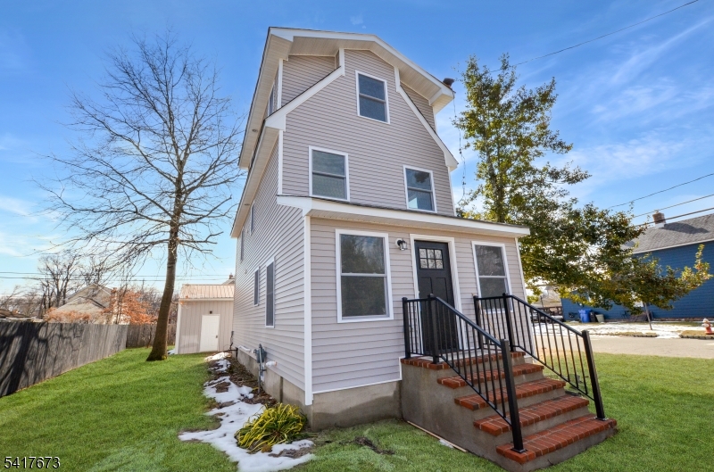 Completely rebuilt, this stunning 4-bedroom, 3-full-bath home offers the feel of new construction with modern finishes throughout. The property has been fully renovated with a brand-new roof, windows, siding, and all new interior wood framing/sheetrock, along with new electrical, plumbing, and a high-efficiency multi zone HVAC system featuring forced hot air heat and central AC, truly a like-new home. New kitchen and new bathrooms entirely. Enter into a bright, open-concept first level showcasing a family room and an open kitchen flooded with natural light from windows throughout the home. The kitchen features sleek quartz countertops, stainless steel appliances, and a modern layout perfect for everyday living and entertaining. Beautiful hardwood floors run throughout all levels of the home, including the staircases. The first floor offers the convenience of a bedroom and full bath, ideal for guests or flexible living arrangements. All three bathrooms have been beautifully finished with new stylish tile flooring, tiled showers, and modern fixtures, adding a cohesive and contemporary touch throughout the home. Upstairs, you'll find additional bedrooms and laundry area. Situated on a desirable corner lot, the property also includes a large detached, two-car garage. Located in a peaceful residential neighborhood with easy access to major highways, shopping, and dining. Property may qualify for 0% down payment financing. Grass digitally enhanced.
