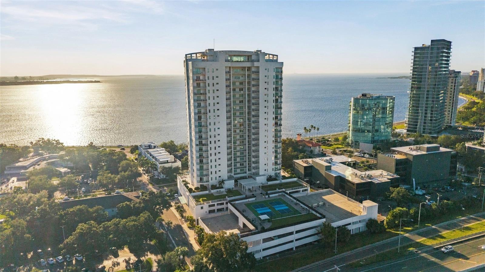 Some homes are beautiful. Others change the way you live. Welcome to Residence 904 at Altura on Bayshore.Imagine waking to the morning light over Hillsborough Bay, enjoying coffee on your private balcony overlooking iconic Bayshore Boulevard, and ending the day with a spectacular sunset. At Altura, breathtaking views, exceptional amenities, and thoughtful upgrades come together in one of South Tampa's most desirable waterfront settings.Perched on the ninth floor, this 3-bedroom, 3.5-bath residence offers 2,522 square feet of beautifully designed living space. Engineered hardwood floors, custom ceilings with recessed lighting, and expansive windows create a bright, inviting atmosphere that feels elegant yet comfortable. Every space makes everyday living as enjoyable as entertaining.The kitchen is as beautiful as it is functional, with waterfall-edge countertops, upgraded cabinetry, and Thermador appliances, including separate full-size refrigerator and freezer columns and a warming drawer. Thoughtful additions include a Magic Corner cabinet system, pull-out storage, extra island cabinetry, under-cabinet lighting, and an instant hot and drinking water dispenser.Throughout the residence, the owners have invested in upgrades that enhance comfort and convenience. Hunter Douglas Silhouette shades, PowerView motorized shades, Lutron smart lighting, and custom ceiling lighting transition effortlessly from bright mornings to intimate evenings. The primary suite is a peaceful retreat with a custom walk-in closet by The Closet Envy, featuring built-ins and valet rods. Additional upgrades include a WaterCop leak detection system with automatic shutoff, custom laundry cabinetry with a utility sink, and additional storage.Practical details are equally impressive: two premium side-by-side parking spaces near the elevator, a dedicated EV charger, and private storage with added privacy and wind protection.And then there is everything that comes with calling Altura home.Imagine weekends by the rooftop resort-style pool, relaxing in the spa, or gathering with friends around the fire pit as the sun sets over Tampa Bay. The rooftop also features shaded cabanas, grilling areas, a beautiful clubroom, and entertaining spaces with incredible water and skyline views.On the fourth-floor amenity level, enjoy a fitness center overlooking the bay, pickleball and bocce courts, a putting green, a dog park, and two guest suites available for residents to reserve when friends and family visit.The location is equally compelling. Step outside to Bayshore Boulevard's waterfront sidewalk for morning walks, evening runs, or simply enjoying Tampa's waterfront. Restaurants at neighboring Bayshore Gardens are steps away, while Howard and MacDill Avenues, Hyde Park Village, and Downtown Tampa are within easy reach.And when Gasparilla comes to town, imagine watching the festivities and fireworks from an entirely different perspective.Residence 904 is more than a beautiful place to live. It's the freedom to enjoy Tampa at its best, with incredible views, resort-style amenities, and a home where so many details have already been taken care of. All that's left is to make it yours.