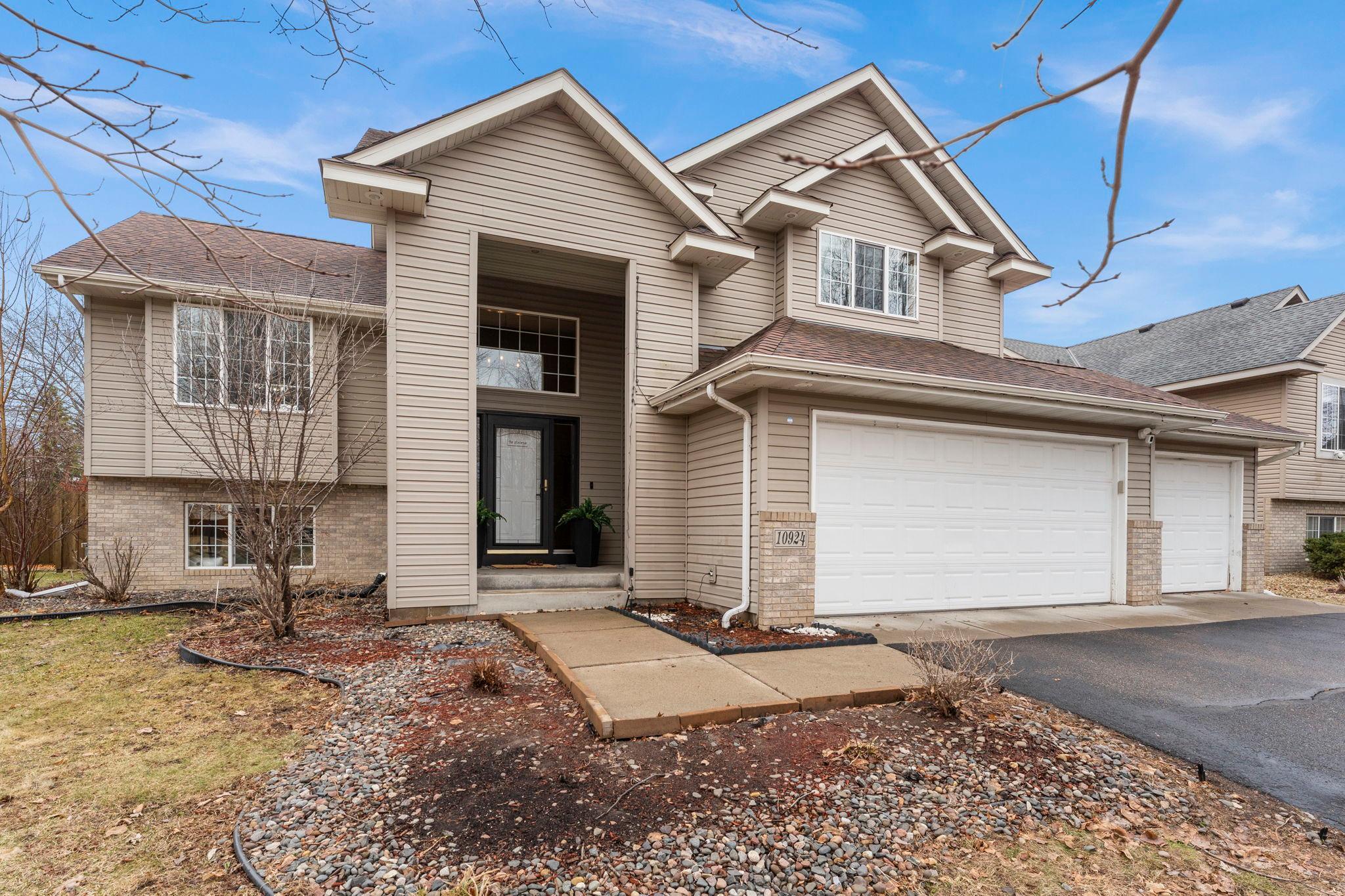 Character, space, and comfort unite in this stunning 4-bedroom, 3-bathroom Champlin home, perfectly situated near parks with quick access to major roads. The open, flowing main level impresses with vaulted ceilings, soft carpeting, and oversized windows that fill every room with light. The chef-ready kitchen shines with stainless steel appliances, a center island, stylish backsplash, and a closet pantry, seamlessly connecting to a dining area with statement lighting and walkout access to a large deck, ideal for effortless indoor-outdoor entertaining.The primary suite is a true retreat with a unique two-level layout, French door entry, plush carpeting, dual walk-in closets, and a private bath. Two additional main-level bedrooms share a full bathroom with convenient hall storage. The lower level expands your living options with a spacious family room anchored by a gas fireplace, built-in speakers, and a wet bar with beverage fridge. A fourth bedroom and full bathroom complete the lower level, along with laundry and extra storage.A 3-car garage features a third stall with double barn doors to the backyard. Large enough to fit a vehicle, oversized gear, or boat! The fully fenced yard and expansive deck create the perfect private outdoor oasis.