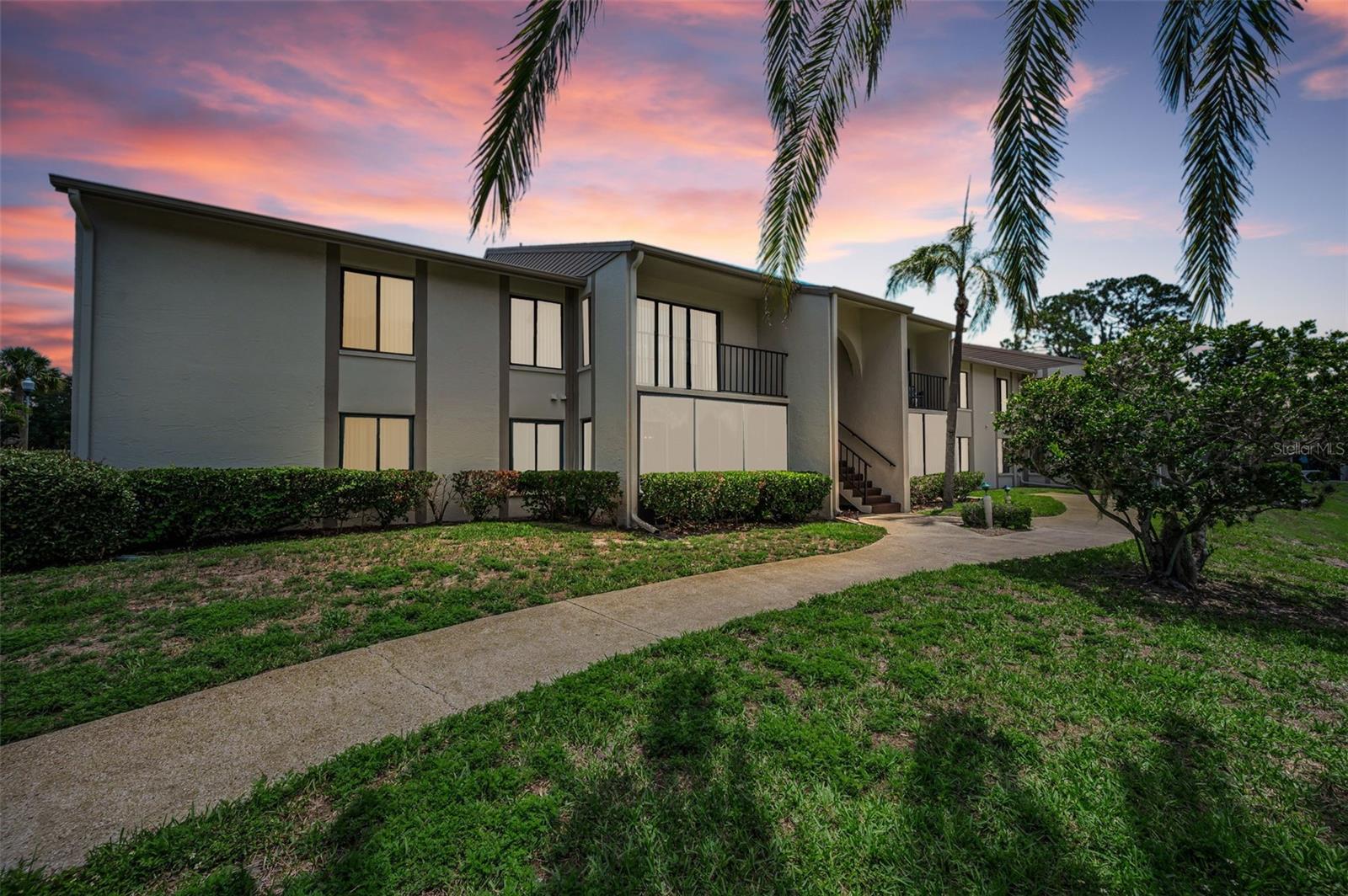 Welcome to waterfront living in the highly desirable 55+ community of Pine Ridge at Palm Harbor! This rare first-floor, pet-friendly condo offers the largest 2-bedroom, 2-bathroom floor plan in the community, featuring an expansive living area filled with abundant natural light and tranquil water views. Located in a Non-Flood Zone, designed for both comfort and peace of mind, the home is equipped with hurricane impact windows and sliding glass doors that open to a cozy enclosed patio with porcelain tile flooring and screened windows—perfect for enjoying the quiet waterfront setting year-round.The updated kitchen features solid wood cabinetry and upgraded appliances (2018), while an adjacent utility closet conveniently houses the HVAC system (2023), hot water heater (2022), and washer and dryer (2022). Luxury vinyl wide-plank flooring flows throughout the bedrooms, hallway, and bathrooms, adding a modern touch and easy maintenance.The spacious primary suite includes a walk-in closet and a beautifully renovated bathroom with a modern tiled walk-in shower, updated vanity, and quartz countertop. The guest bathroom offers a full bathtub along with an updated vanity and quartz countertop.Residents of Pine Ridge enjoy a welcoming, active lifestyle with beautifully maintained grounds, paved walking trails, a clubhouse, shuffleboard courts, heated pool and spa, outdoor grilling area, on-site management, and a variety of social activities. Low HOA fees cover cable, internet, water, sewer, trash, roof maintenance, exterior maintenance, exterior pest control, pool access, and more.This is a rare opportunity to own an updated waterfront condo in one of Palm Harbor’s most sought-after active adult communities. Leasing allowed with a 3 month minimum contract and can lease immediately upon new ownership. Schedule your private in-person or live virtual tour today!
