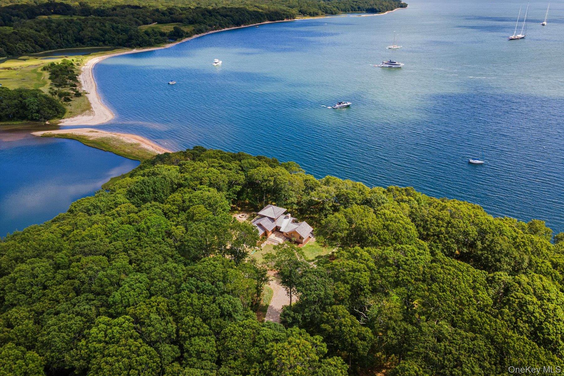 A Kenton von Boer Masterpiece on Smiths Cove
    Perched 29 feet above sea level for commanding views and peace of mind, this exceptional contemporary estate spans 9.4 private acres, of which 2.7 acres are buildable, and offers 561 feet of premier waterfront on Smiths Cove. Sweeping panoramic vistas of the Sound and the tranquil yacht anchorage set the scene for direct beachfront access and creek frontage along the serene Miss Annie’s Creek—plus the rare opportunity to create your own private dock and mooring.
    Encompassing 1,755 square feet of refined living space, the home features 3 bedrooms and 2 spa-inspired full baths. A chef’s kitchen anchors the open layout, flowing into a light-filled living room with a stone-accented fireplace and a custom built-in dining area. Thoughtful architectural details—warm wood tones, natural stone elements, and walls of glass—create an effortless connection between indoors and out.
    Nestled in a serene coastal setting of wood shingles, flagstone patios, and unspoiled shoreline, this property offers unmatched privacy while being just moments from the Shelter Island Ferry to Sag Harbor. A rare blend of seclusion, convenience, and timeless design.