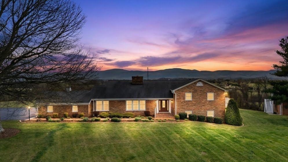 Set high above Glade Spring, this custom home showcases panoramic views of Whitetop Mountain and Mount Rogers known as the "Rooftop of Virginia" from both the interior and rear deck. Crafted in brick and stone, this tri-level residence offers over 4,200 +- sq. ft. of well-designed living space.  Lovingly built by its original owner and impeccably maintained, it reflects enduring quality with select updates throughout. Designed for both comfort and luxury, the main level showcases sunlit living and dining areas with beautiful hardwood floors and a seamless, open flow.  The Great Room features a gas log fireplace, striking brick feature wall, and a dramatic wall of windows, all leading to an expansive composite rear deck where mountain views become part of everyday living.   The kitchen-truly the heart of the home-has been thoughtfully designed to blend elevated style with exceptional function. Outfitted for the serious cook and the effortless entertainer alike, it features quartz countertops, double ovens, dual cooktops, a prep sink and even an indoor grill-an uncommon & impressive touch that sets this home apart.  Rich, custom cabinetry & expansive prep space create a warm, inviting backdrop for everything from quiet mornings to lively gatherings, while an organized pantry with tailored pull-outs keeps daily living seamless & refined.  The sunlit breakfast room is open to the kitchen. The main floor primary bedroom includes an adjoining office, luxurious spa-style bath, designer walk-in closet, & rear deck access.  Upstairs, three spacious bedrooms each feature their own baths, offering comfort and privacy for family or guests. The lower level adds a versatile den/recreation room, bedroom #5 with full bath, and a vintage vibe Laundry with 2 chutes--Perfect for multi-generational living or guests.  Don't miss this one-of-a-kind opportunity to own a well-built classic in a premier setting, combining enduring quality, modern upgrades, & still room to make it your own.
