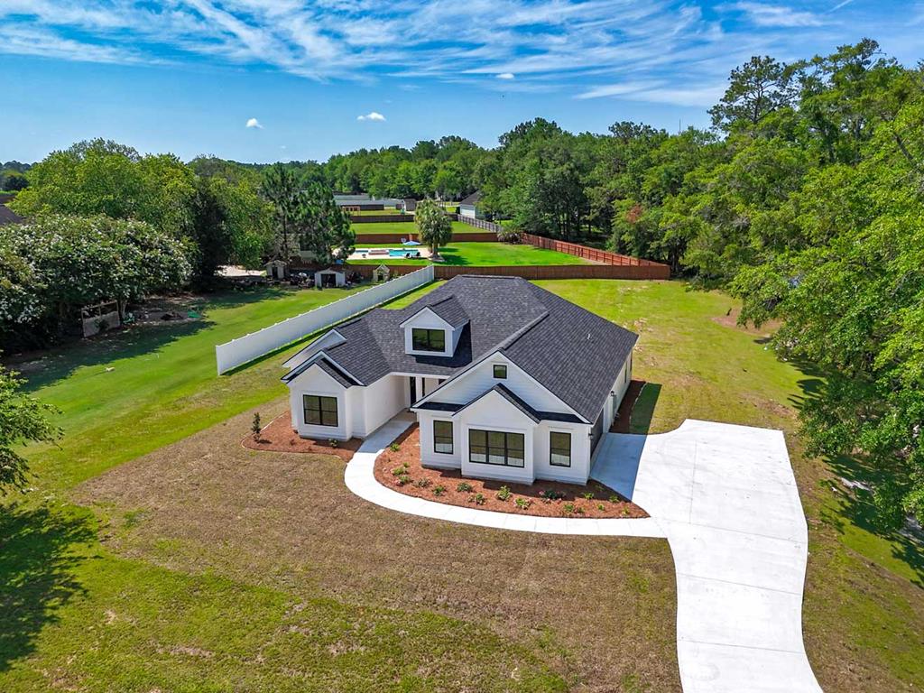 Waterfront and located in a cul-de-sac in one of Thomasville's most sought after neighborhoods!!! Stunning new construction home with so many upgrades in the highly desirable Heards Pond community! Situated on a spacious 1.16-acre lot, this thoughtfully designed 3-bedroom, 2-bath residence offers 1,952 square feet of beautifully crafted living space that perfectly blends comfort, style, and functionality.  From the moment you arrive, the home's clean architectural lines, modern farmhouse-inspired exterior, and expansive setting create striking curb appeal. Inside, you'll find a bright and open-concept layout designed for both everyday living and effortless entertaining.  The beautifully appointed kitchen features quartz countertops, stainless steel appliances, a gas range, ample cabinetry, and a spacious island overlooking the inviting great room—creating the perfect central gathering space for family and friends. Large windows throughout the home bring in natural light and showcase the peaceful surroundings.  The primary suite offers a private retreat with a beautifully finished ensuite bath featuring a tiled walk-in shower, double vanity, and a spacious walk-in closet. The guest bathroom also includes a double vanity, adding extra convenience for family and visitors alike.  Designed with practicality in mind, this home also features a dedicated mud room and a spacious 2-car garage, providing the storage and organization space today's buyers are looking for. The additional bedrooms offer flexibility for guests, family, or a home office setup.  Step outside to enjoy the covered back patio—perfect for relaxing, grilling, or entertaining—while taking in the privacy, open green space, and peaceful atmosphere that make Heards Pond so special. Located in the sought-after Heards Pond community, this home provides a tranquil setting while remaining conveniently close to shopping, dining, schools, and everyday amenities.  With quality craftsmanship, modern finishes, a thoughtfully designed floor plan, and an incredible homesite, this exceptional new construction home is one you won't want to miss!