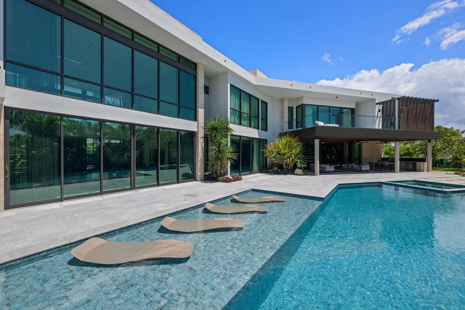 Experience the ultimate in resort-style living with this newly constructed and fully furnished luxury residence, located in the exclusive Dorado Country Estate lot 36 in Dorado. Perfectly situated on an elevated 2,419m² (approx.) a corner lot within an exclusive community, this property offers 8 bedrooms, 10 bathrooms, and an impressive 14,267 sq. ft. (approx.) of gross floor area, thoughtfully designed to combine elegance, comfort and functionality.The air-conditioned interior includes 9,573 sq. ft. (approx.) of main living space and 1,033 sq. ft. (approx.) of garage. Additional covered spaces include 894 sq. ft. (approx.) of covered terraces and 91 sq. ft. (approx.) of utility rooms. Outdoor areas add another 2,201 sq. ft. (approx.), plus 475 sq. ft. (approx.) of dedicated utility area, creating a resort-like retreat ideal for both indoor and outdoor living. A private elevator, premium finishes and three integrated control panels further elevate the living experience.Equipped for both luxury and self-sufficiency, the residence features an 80 kW generator, three solar water heaters, two 900-gallon cisterns, a water softener and 10 exterior security cameras. Electric blinds and a premium sound system indoor and outdoor ensure maximum comfort. The property features Airmaster windows and doors, tested and certified to withstand impacts, water infiltration and hurricane force winds.The exterior is equally remarkable, boasting spacious terraces, lush gardens with professional irrigation and lighting, a resort-style swimming pool and a versatile jacuzzi that can be enjoyed heated for relaxation or as a refreshing cold plunge bath. A three car garage plus golf cart space complements an incredible 4,900 sq. ft. (approx.) paver driveway, offering a spectacular entrance and abundant parking.Located within Dorado’s most sought-after community, this home offers not only resort-inspired amenities but also the security and exclusivity of Dorado Country Estates, with a monthly HOA fee of $488.