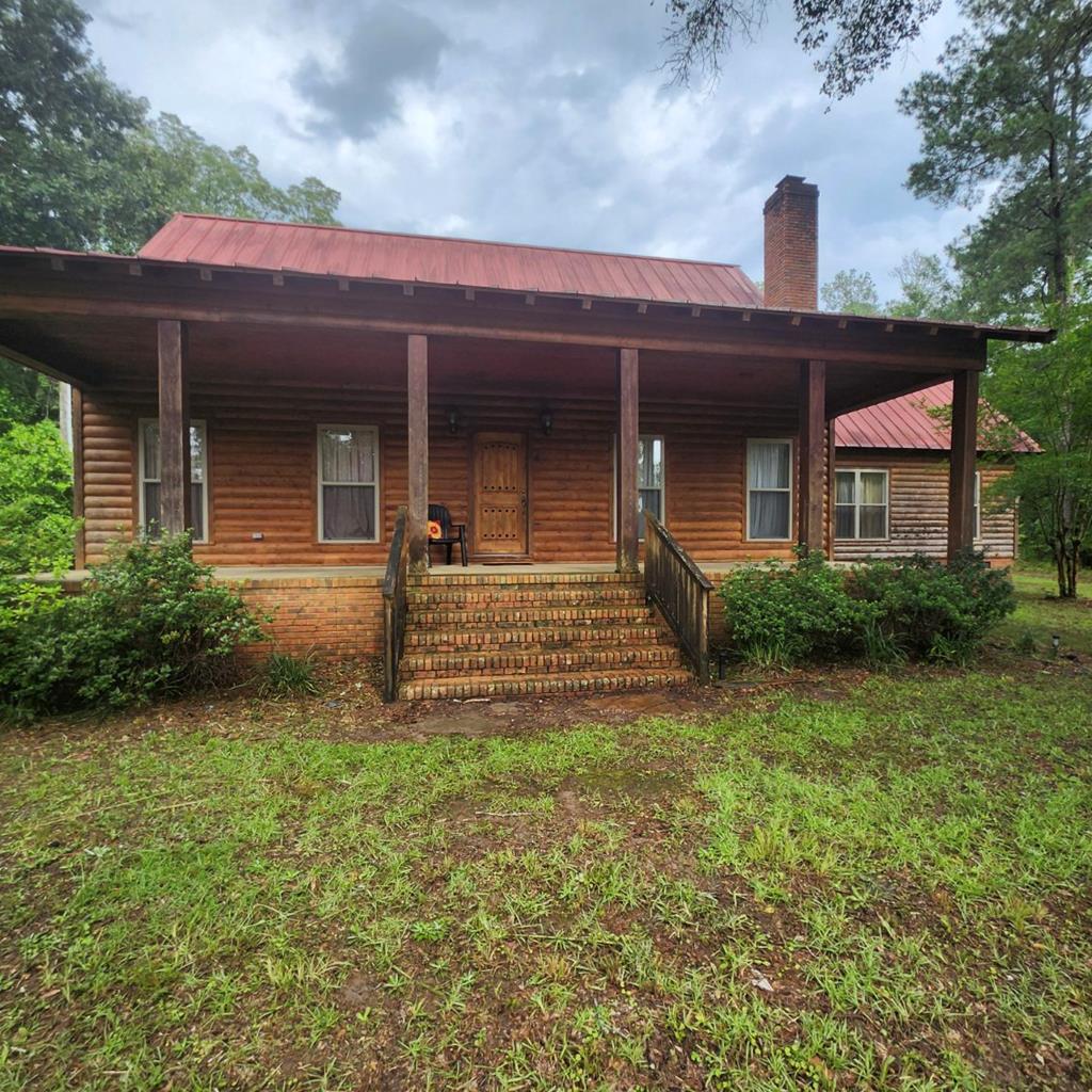 Experience serene living with this charming 4.65-acre log cabin property featuring creek frontage, dual master suites, and extensive outdoor amenities.  Tucked away behind a gated entrance, this picturesque log cabin offers privacy and tranquility on a generous 4.65-acre parcel with direct creek frontage, perfect for nature lovers and outdoor enthusiasts. The property includes two spacious master suites, providing comfort and flexibility for family or guests.  Enjoy the beauty of both a large front porch and a back porch, ideal for relaxing, entertaining, or taking in the scenic views. Additional structures include a shed and a pole barn, offering ample space for storage, hobbies, or workshop needs. The property also features a single-wide mobile home that requires some TLC, providing potential for rental income, guest accommodations, or renovation to expand living options.  Nestled in the heart of Leary, GA, this property combines the rustic charm of a log cabin with practical amenities. The creek running along the land enhances the peaceful ambiance, making it a perfect retreat from city life while remaining conveniently accessible to local amenities and major routes.  This property is an exceptional opportunity to own a sprawling, scenic homestead in Southwest Georgia, offering a rare combination of waterfront charm, rustic living, and functional outdoor structures  For buyers seeking peace, privacy, and the perfect blend of rustic and functional living, this Leary log cabin acreage is ready to welcome you home.
