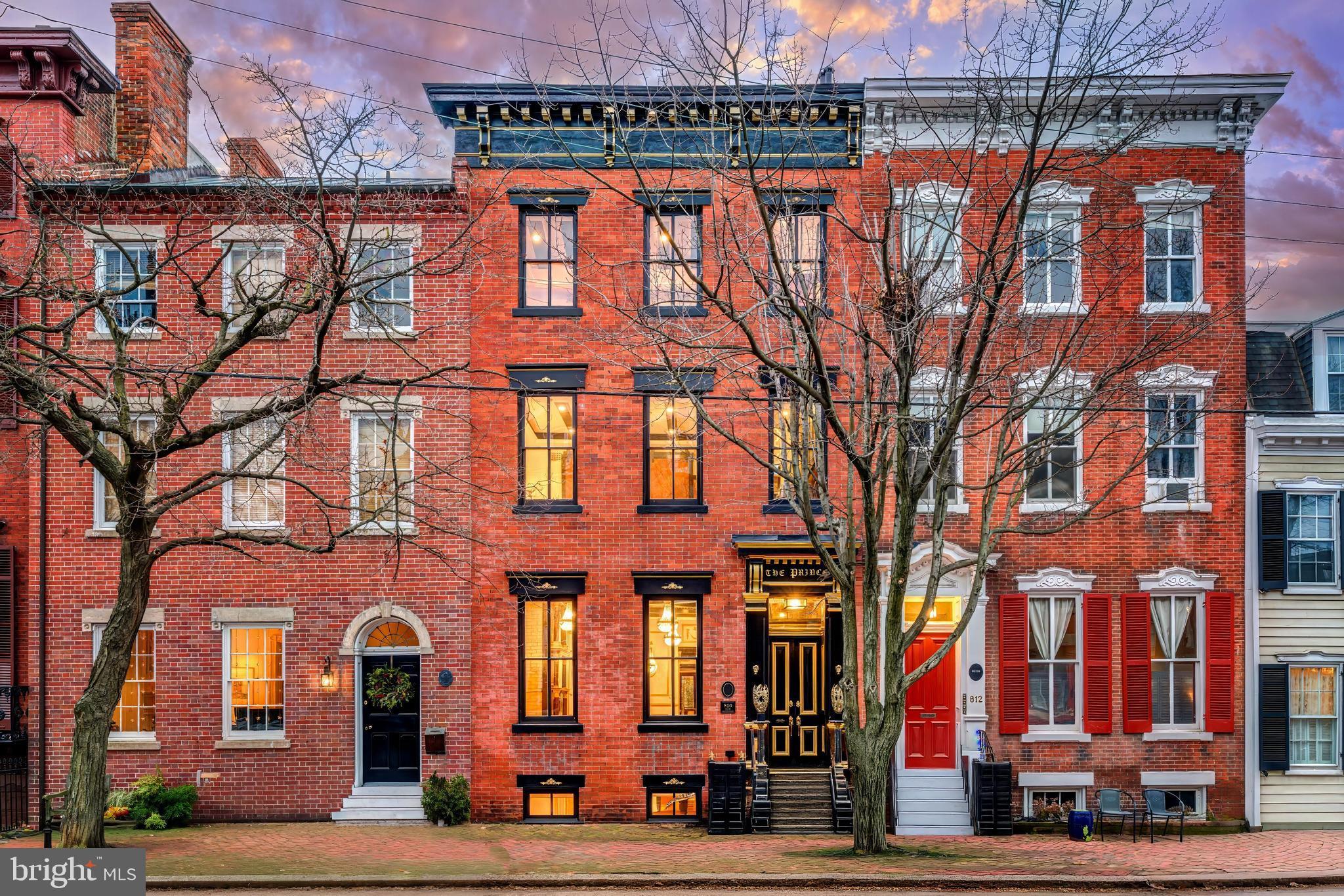 Introducing The Prince, often referred to as the Versailles of Old Town, a once-in-a-generation opportunity to own one of the most architecturally distinctive and thoughtfully crafted residences ever offered in Historic Old Town Alexandria. Behind a classic Federal-style brick façade lies a fully restored and reimagined historic townhouse where 1830s Colonial heritage meets refined European craftsmanship and modern smart-home living. Years in the making, The Prince was designed with exceptional detail, provenance, and presence. Spanning six bedrooms and four-and-a-half bathrooms across four finished interior levels, the home is crowned by a fifth-level rooftop deck offering 360-degree views over Old Town with partial views of the Potomac. This rooftop is the only known fully approved and constructed 360-degree rooftop deck on a historic residence within the Old and Historic District of Old Town Alexandria, making it truly irreplaceable. Throughout the residence, original architectural elements are preserved and elevated through imported European materials, curated Early American and European antiques and artifacts (many of which convey), and extraordinary attention to detail. Imported marble flooring with gold inlays, bespoke millwork, designer fixtures, and globally sourced finishes are layered seamlessly over original brick and wood, creating a home that feels both grand and warmly livable. The original staircase has been transformed into a striking architectural centerpiece, encased in glass with custom lighting. A rare manual dumbwaiter discovered during restoration has been thoughtfully mechanized and incorporated as a functional historic feature, honoring the home’s past while supporting modern living.Designed for both elegant entertaining and everyday comfort, the home features eight fireplaces, including one in every bedroom. The chef’s kitchen is anchored by a La Cornue range, custom appliances, bespoke cabinetry, and Belvedere quartzite countertops. A concealed motorized television integrated into the main island preserves clean sightlines while allowing the space to transition effortlessly from daily living to hosting at scale. Custom day to night lighting throughout the home enhances the experience from morning elegance to evening ambiance, supported by integrated smart-home technology.The lower level offers a private entrance and functions as a flexible suite with an en-suite bedroom, kitchenette, living area, and washer/dryer, ideal for guests, multigenerational living, au pair accommodations, a private retreat, or potential rental use.Outdoor spaces are equally refined, featuring a serene garden courtyard with six fountains, a star-lit archway, ambient lighting, and multiple outdoor entertaining areas. Above it all, the rooftop deck serves as a private sky lounge with seating, dining space, outdoor theater, putting green, and panoramic views across the Old Town skyline toward Washington, DC, Maryland, and the Potomac River.In a city where parking is an exceptional premium, The Prince offers rare off-street parking, including a private gated garage capable of accommodating up to four compact vehicles, along with resident guest-only alley accessible parking. The property also features the largest carport door ever approved and installed within the Old and Historic District. Located just one block from King Street, Old Town’s main thoroughfare for acclaimed restaurants, boutiques, galleries, and cultural landmarks, the setting could not be more central or walkable. Combined with immediate access to Reagan National Airport, Washington, DC, and Maryland, The Prince offers a lifestyle that is as effortless as it is extraordinary.