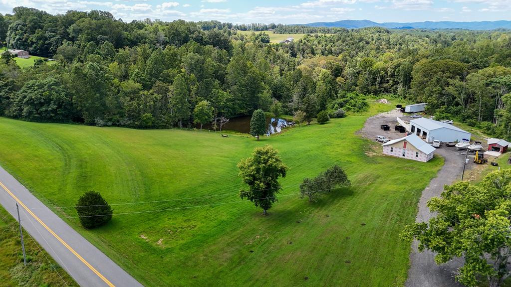 Discover the perfect blend of potential and practicality with this beautiful 15.93 acre property located just minutes from Stuart, VA. A 30' x 40' unfinished cottage-style building sits on the property — all permits are in place and ready for completion into your dream home or other possibilities. Behind the cottage is a large 48' x 50' workshop featuring three automotive lifts, a roll-up door, electric service, and a concrete floor — ideal for car enthusiasts, hobbyists, or a small business operation. Additional improvements include a 10' x 10' metal building with a concrete floor, perfect for storage or tools. Enjoy your own private pond stocked with fish, offering a serene place to relax, unwind, or enjoy recreational fishing. Set in a beautiful rural location just 10 minutes from Stuart, 30 minutes from Martinsville, 35 minutes from Meadows of Dan and the Blue Ridge Parkway, and 40 minutes from Mount Airy, NC. Whether you're looking for a homestead, country retreat, or a property with space for hobbies and and business, this versatile tract has it all.