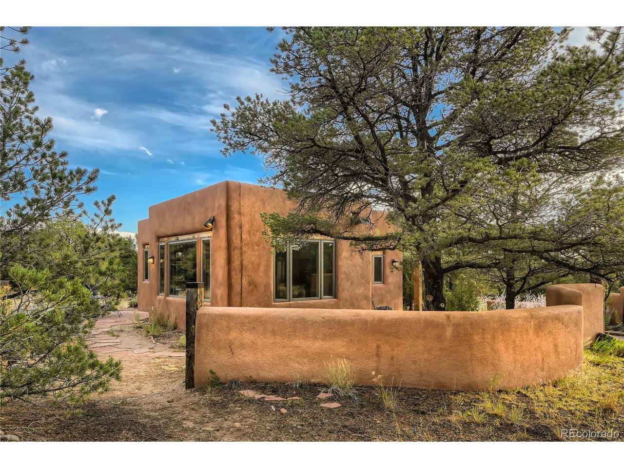 Step inside this bright 2BD/1BA retreat & feel the embrace of sacred geometrical design, quality SW-style construction, and views of mtns & nature from every room. Whether permanent, second or investment home, discover privacy, solitude & undisturbed nature in the Baca Grande, a true refuge from the hustle & bustle of modern life. Famous for awe-inspiring, 14,000-ft mountain peaks & pristine nature, the Baca features staffed firehouse, hydrants, EMTs, parks, trails, rustic golf/tennis & more. From the moment you enter the casita, you're met w/ expansive views of the Sangre de Cristos, highlighted by Challenger Pt rising immediately to the east. Oversized tin-clad windows provide the sense of living within nature. Imagine daily life unfolding against this stunning backdrop! Set back from the road, down a long pvt drive, you are welcomed by a cozy flagstone courtyard w/ shade, blossoming trees & covered entrance. The great room is bathed in natural light, w/ handsome, polished concrete slab, featuring the luxurious comfort of hydronic in-floor heat. Surprisingly spacious, the open-concept great room has space for dining, living, a wood stove, dancing & more. The side door leads to the flagstone patio, for easy al fresco dining/entertaining. Well-organized kitchen w/ new stainless fridge, ample counterspace & custom wood cabinets. The hallway leads to full custom bath w/ view & two bright bedrooms. The primary bedroom faces the greenbelt, overlooking Willow Creek. Watch the wildlife come & go for a drink. When the windows are open, drift off to the gentle sounds of the gurgling creek. The laundry/utility room houses washer, dryer, LP boiler & water heater. Custom features include nicho, bullnose corners, flagstone hearth, high pine ceilings & more. Set on almost 2 acres of private, greenbelt-adjacent land, location is exceptional. Nearby Willow Park & Dream Way, leading to spiritual centers.