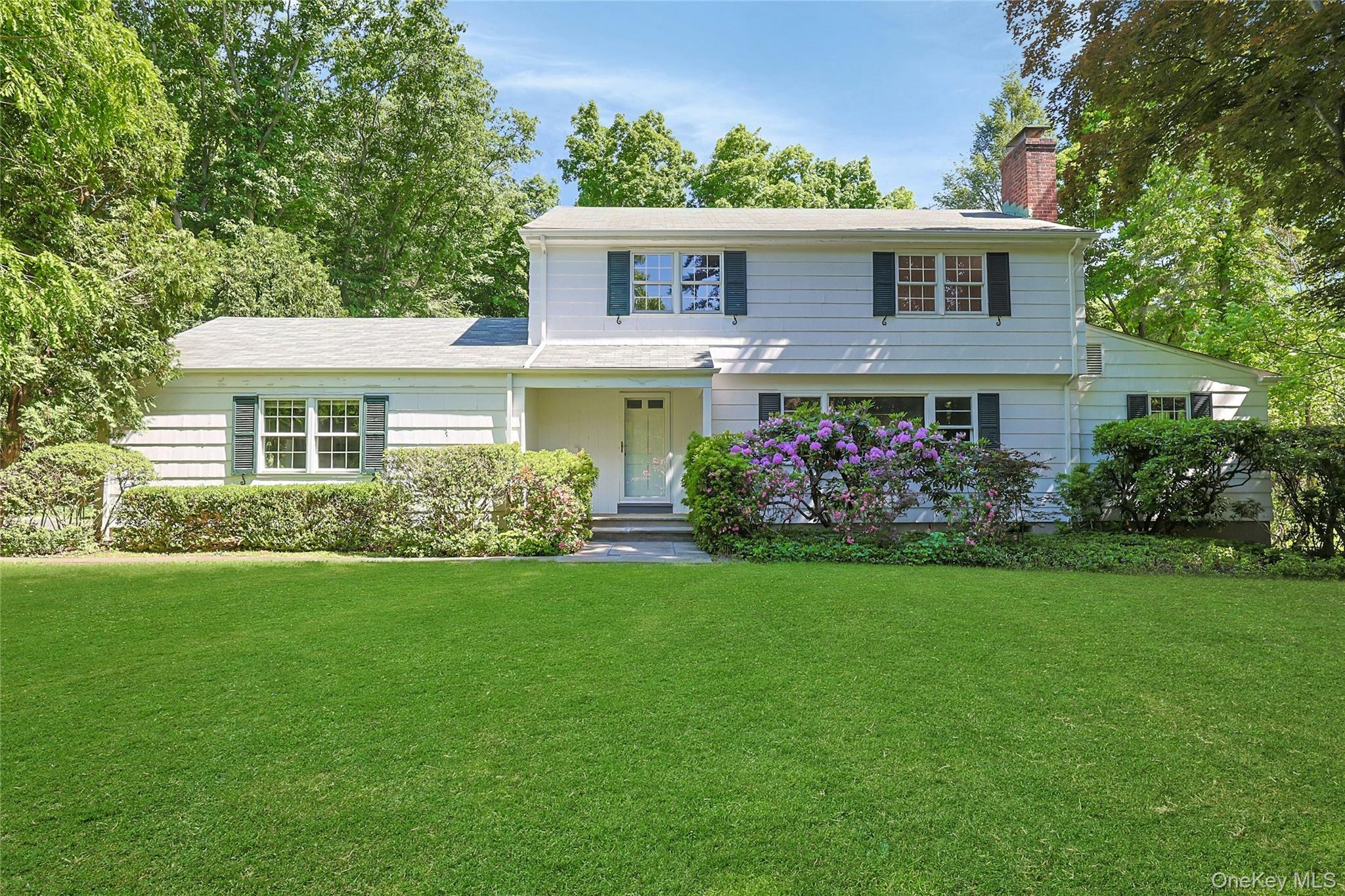Location, location, location! Traditional 3-bedroom, 2.1-bath colonial-style home serenely set on a prime, flat 1.14-acre parcel. Covered front portico. Spacious living room with wood burning fireplace and hardwood flooring. Formal dining room with bay window, hardwood flooring and door to sunroom (additional 150sqft not included in total) with garden sink and slider to deck with steps to backyard. Eat-in kitchen with picture window to backyard and GE appliances including 4-burner electric cooktop, double in-wall ovens, refrigerator/freezer and dishwasher. Private home office. Rear entryway with powder room and main-level garage access. Rear-corner primary bedroom with two closets and private ensuite bath. Front-corner bedroom and front-facing bedroom with closet access to walk-up, unfinished attic share hall bath with shower over bathtub. Walk-out basement offers recreation room with wood-burning fireplace (additional 400+/-sqft not included in total), large unfinished storage or workshop and utility/laundry room with Whirlpool washer, Maytag dryer, slop sink and door to side yard. New indoor above-ground oil tank. Flat, easy driveway. Rare, flat-as-a-pancake backyard surrounded with lush and mature landscaping. One of the most sought-after neighborhoods in Chappaqua within walking distance to school and close proximity to shops, town and train. A prime opportunity.