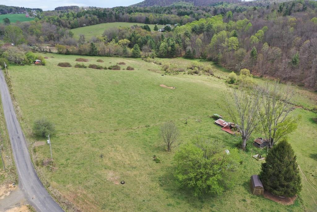 Beautiful pasture land with a creek flowing through the back of the property.  A small portion of the property is wooded.   Most of the land is fairly level and clear.There is a 1938 home on the property but the feasibility of restoring it is unknown.  There are 3 old mobile homes also on the property.  There are 2 septic systems and wells that were used with the mobile homes and 1 septic system and well used with the house.  Their status is unknown.   There is a newer lawn building near the house, as well as some older sheds.  The property is fenced primarily with an electric fence and there are currently cattle on the property.