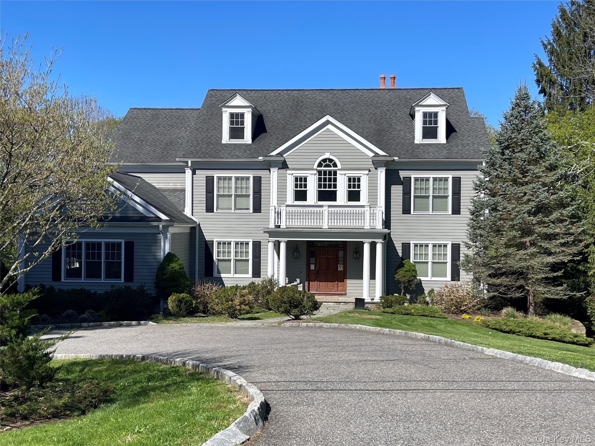 Stunning curb appeal sets the tone for this exceptional 5726 sq ft colonial in the heart of Armonk, set back from the road along a graceful flat driveway approach and sited on 1.09 acres of park-like, level grounds. Three beautifully finished levels offer 5 bedrooms, 5.1 baths, and an effortlessly flowing layout designed for both everyday living and elegant entertaining.A soaring double-height entry welcomes you into sun-filled formal spaces, including a living room and dining room with classic wainscoting and paneling and a butler’s pantry. Rich oak hardwood floors and coffered ceilings carry throughout the main level, where a spectacular kitchen anchors the heart of the home, featuring a large center island with seating, granite counters, stainless appliances, and a bright breakfast area with French doors opening to the outdoors. The adjoining family room with fireplace creates a seamless open flow. A generous mudroom with built-ins, main-level laundry, 3-car garage, and a guest/nanny suite with full bath complete this level with exceptional convenience. Upstairs, the primary suite impresses with a king-size bedroom, tray ceiling, oak floors, oversized walk-in closets, and a luxurious en-suite marble spa style bath. Three additional bedrooms-two sharing an adjoining bath, one with an en-suite bath, and a second laundry area round out the floor. The walk-out lower level adds tremendous versatility with a fully outfitted media room, office/nanny, wet bar with built-ins, full bath, additional mudroom, and ample storage. All of this in the acclaimed Byram Hills school district, moments from Armonk’s charming town center and town pool. Many recent updates including whole house generator and new boiler.