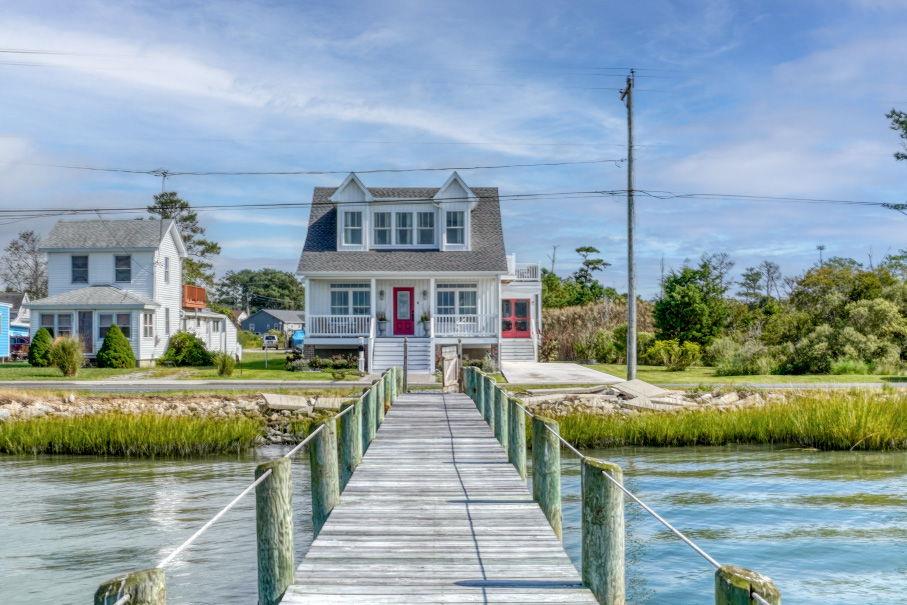 Active/Live MLS date is 12/26. This beautifully renovated 3BR/3BA home offers breathtaking bay views, a 380 ft private dock w/ slip, & inviting spaces to relax in a true coastal setting. Enjoy an open floor plan w/ 9 ft ceilings, distressed ash floors, a bright modern kitchen, & a living room w/ a unique gas fireplace framed by 1850s stained-glass windows. The first floor features 2 bedrooms & 2 full baths, including a private suite, plus a hot tub room & screened porch. Upstairs, the primary suite offers a spa-like bath with a 72" soaking tub and decorative fireplace, a sunset deck, and an office area. Added exterior amenities include an EV charger & outdoor shower. Live the island lifestyle—fresh seafood, beaches, & unforgettable sunsets all from your own exceptional waterfront retreat!