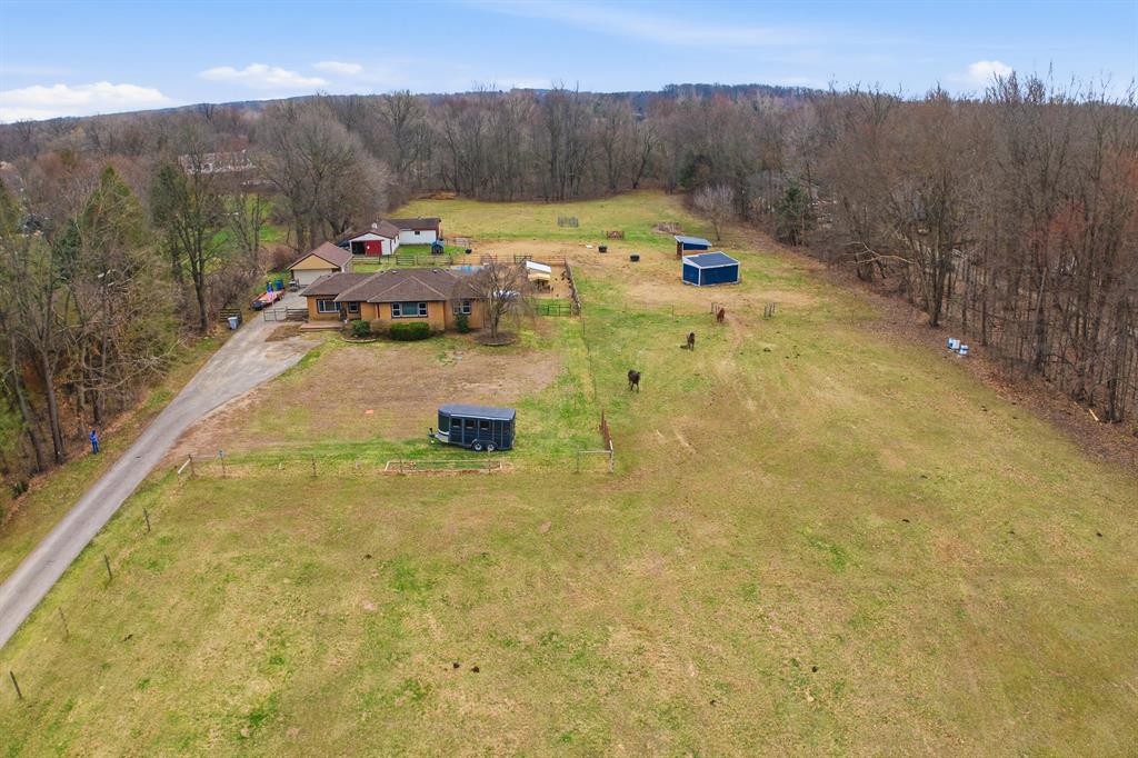 Charming 3-bedroom brick ranch on 5 horse-ready acres in Lyon Township! Built in 1958, this home offers a functional layout with a spacious living room, cozy family room, and a kitchen with eating space. One full bath and a full unfinished basement provide great potential, featuring laundry, a fireplace, and a canning/cellar room. Major updates include a new septic system (2024), roof (2025), and gutters with improved grading (2026). The property is ideal for hobby farming or equestrian use, with three pastures featuring wood and braided electric fencing, plus two run-in shelters (20'x12' and 16'x12'). The barn includes a 38'x13' stable with three 12'x12' matted stalls and cement aisle, along with a 20'x30' storage area for hay and tack. Additional highlights include a 20'x24' detached garage and a chicken coop. Conveniently located near Kensington, Proud Lake, and Brighton riding trails. WANT MORE INFO? Click the Virtual Tour link which has much more detailed information, anenhanced photo gallery and 3D walkthroughs! Do not go to the property without an appointment.