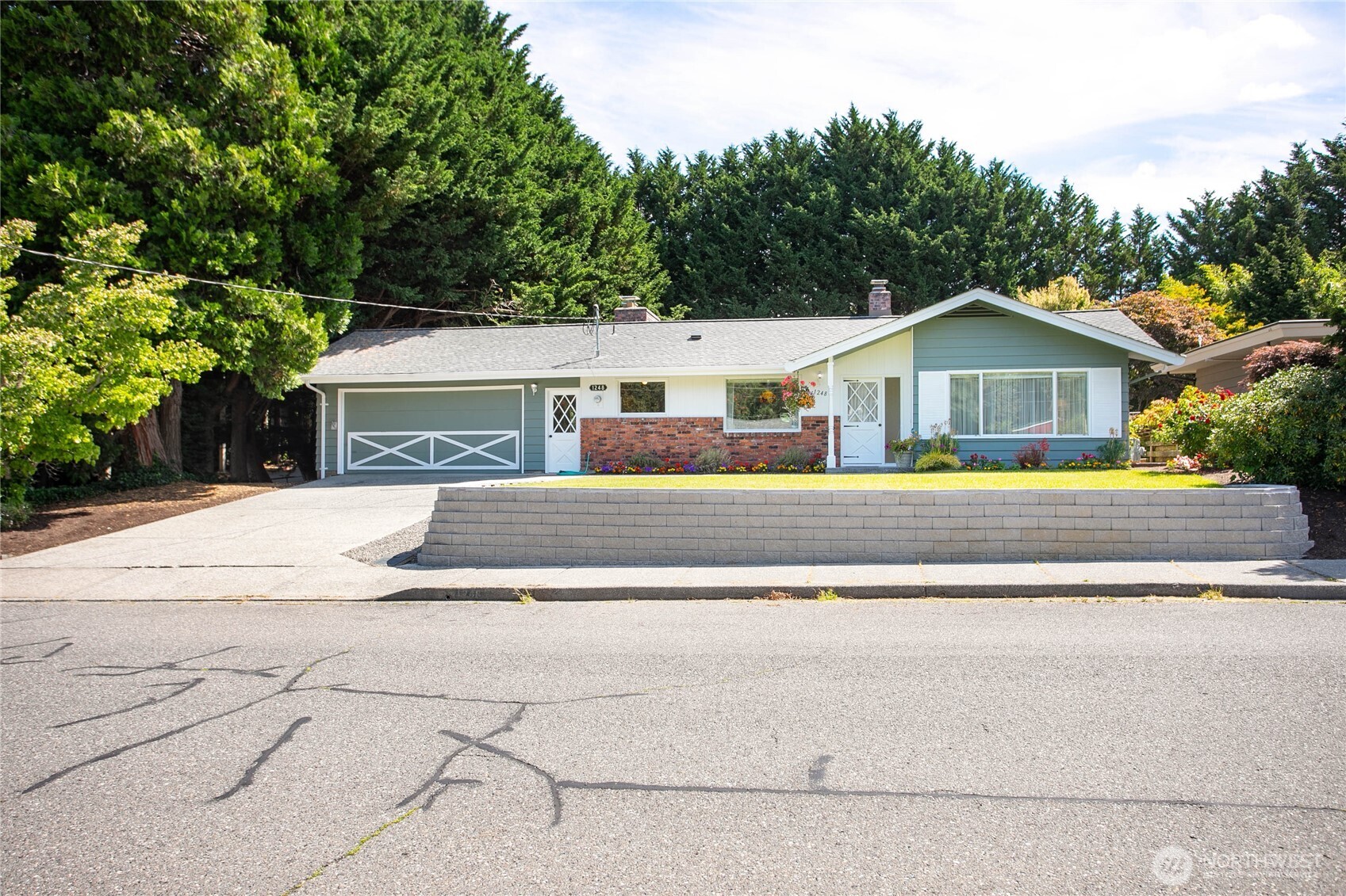Affordable gem in one of the most desirable locations in Bellingham? Yes please! With stunning curb appeal, this over 1,600 sq ft rambler on oversized 9,000 + sq ft corner lot is only steps away from beautiful Whatcom Falls - perfect place to go for a casual hike taking in the falls. Only minutes away from popular Galbraith Mt. where hikers, bikers & avid outdoor enthusiasts flock for its famous 70 mile trail system. Lovely original brick throughout, living room & family room both w/cozy gas fireplaces, owner's suite is HUGE w/full ensuite bath including updated vanity & tile. Main living area is open with exposed beams & room to use your imagination. Nice attached 2 car garage with w/d included. Absolutely beautiful huge backyard with expansive patio, garden beds, and ample privacy taking full advantage of being a corner lot. Truly great opportunity to own in excellent location near everything you could want - shopping, amenities, WWU, and of course lovely Lake Whatcom all nearby - a must see home!