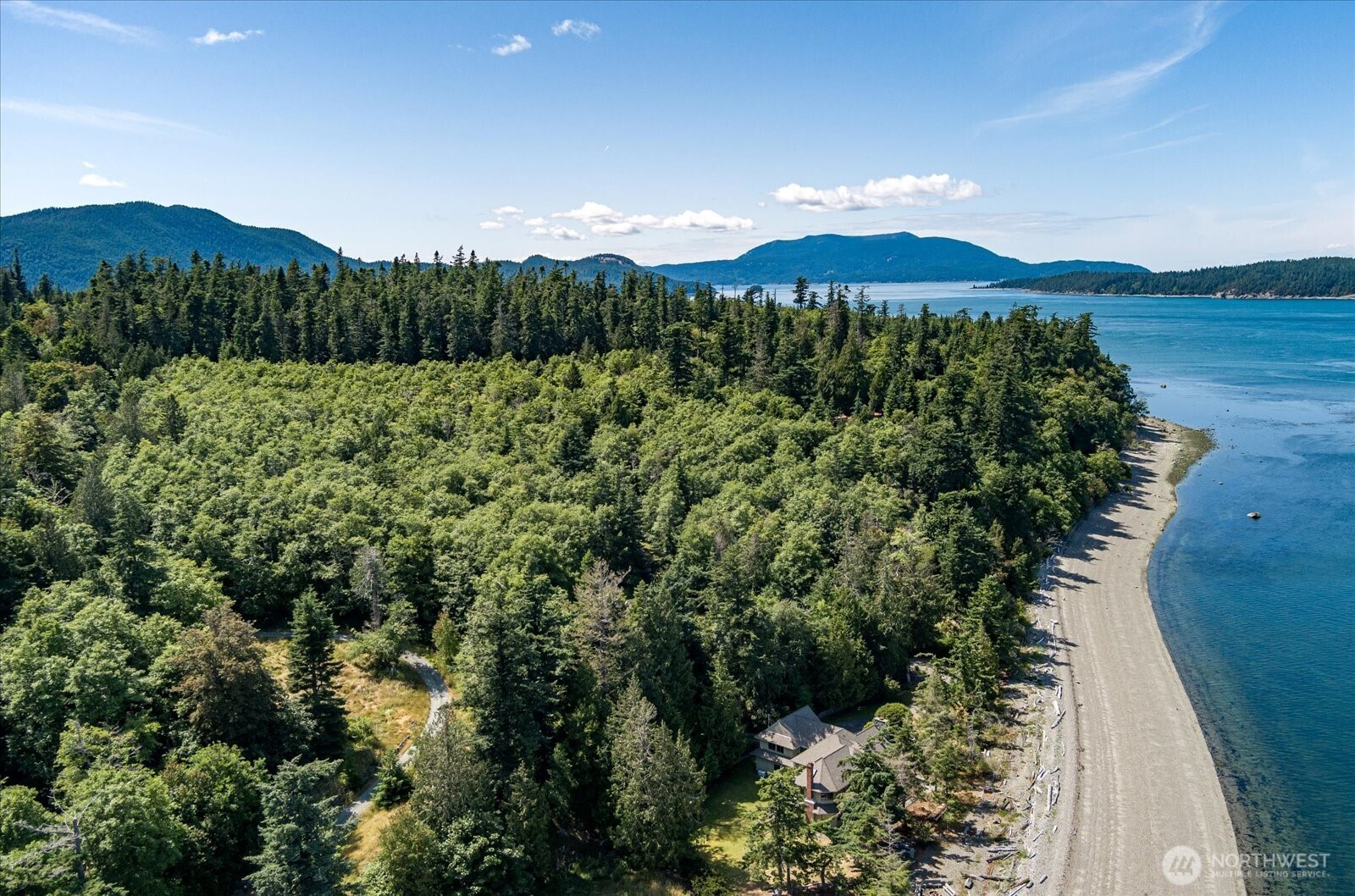 A once-in-a-lifetime opportunity to own a legacy home on 400+ feet of low-bank waterfront on a private shy 8.3 acres - all located on Guemes Island, the 'secret' San Juan Island, a mere 5-minute ferry ride from Anacortes. Fill your days with fishing & crabbing, beach combing & agate hunting,  and even reeling in salmon straight from your own shore. Spend evenings warming by the firepit under a canopy of stars. A private boat launch and deep-water mooring buoy make the Salish Sea your personal playground, while wooded walking paths meander through the property like quiet invitations to wander. The 5,344 sqft main home, with 5 bedrooms & 4 baths, wears its elegant & warm architecture like a well-loved sweater. Clear-grain cedar wraps the living room walls beneath 20' vaulted ceilings, and picture windows frame panoramic, east-facing views of the Salish Sea & Mount Baker; sunrises here feel like a private front-row show. Spend cozy nights by the family room's stone fireplace, retreat to a primary suite with its own fireplace & skylights, and gather around the wet bar for sunset toasts. A separate ADU offers a generous shop for projects below and a 1 bed/1 bath apartment above. Trained Island EMS coupled with dedicated ambulance response from Anacortes provides amazing emergency response time and service. Property has amazing AirBNB potential with no limits on rentals like San Juan County. Do not miss this chance; this one-of-a-kind property truly enchants. See you on the island.
