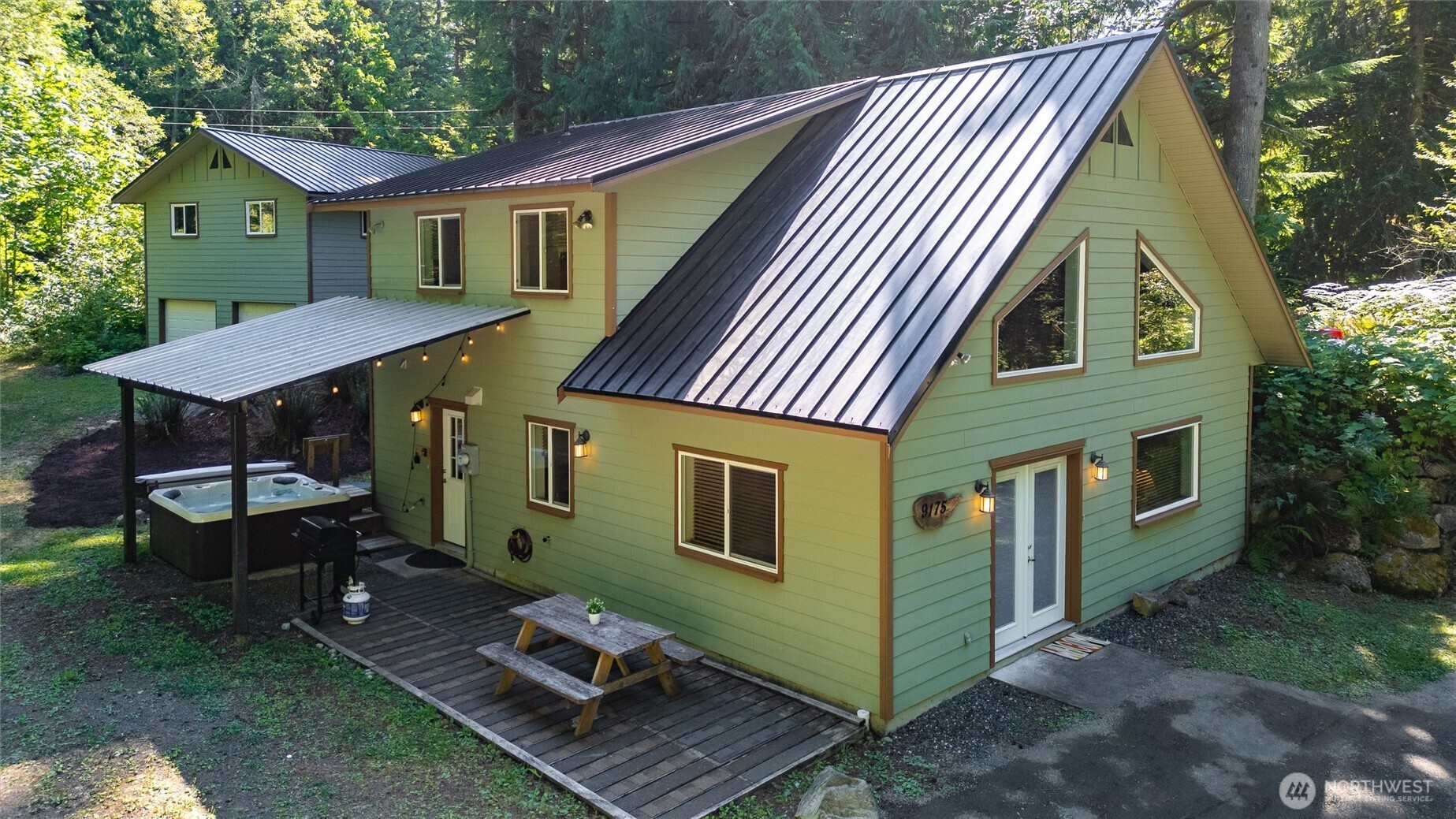 This beautifully kept private chalet-style mountain retreat rests on a tranquil 1.26-acre wooded lot above the Nooksack River. The open floor plan features a spacious kitchen flowing into a vaulted great room, with one bedroom on the main floor, three upstairs, two full baths, a pantry, and laundry room. Enjoy the new hot tub, expansive deck, or gather around the firepit. A rare two-car shop offers added potential with a roughed-in space for an ADU. Currently a thriving Airbnb, this property is perfect as a vacation home, income-generating rental, or full-time mountain escape.
