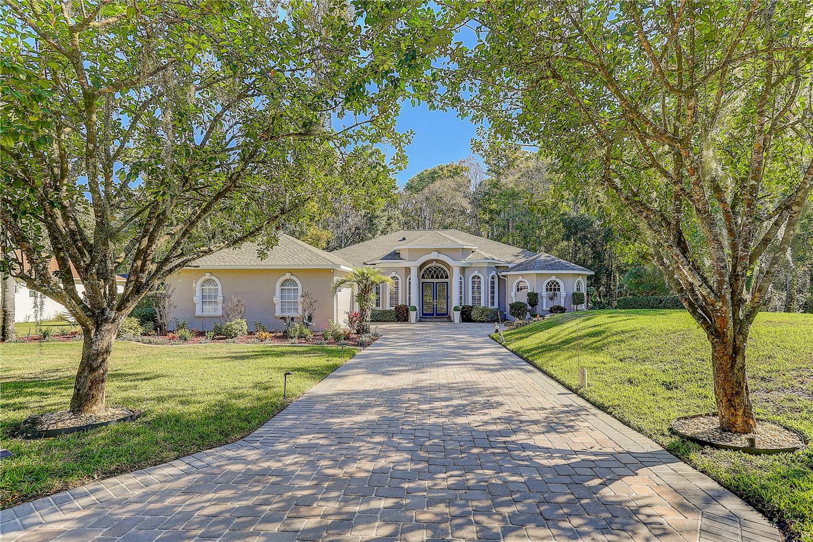 Seller to contribute $10k toward buyer closing costs. A rare hidden gem on 1.62acres, ONLY 30 minutes north of Tampa Airport. This 4 bedroom plus office, 3 full bath 3 garage pool home, offers 3,192 sq. ft. of refined living. NO CDD!LOW HOA, and a spotless record free from hurricane or flood impact, it delivers privacy, elegance, and peace of mind. Estate living begins as stately shade trees anchor the manicured grounds, casting a graceful canopy over the paver driveway that leads to a grand yet welcoming bay covered entry. Step inside: to the right, an office provides a quiet retreat; to the left, a formal dining room sets the stage for elegant gatherings, both with bay windows. The centerpiece is a soaring 12 feet high ceiling, highlighted with a tray ceiling up to 13.5 feet with crown molding. Expansive sliding doors connect seamlessly to the patio and sparkling saltwater pool, fully enclosed by a newly rebuilt no-see-um screen for year-round enjoyment. Beyond, the landscaped backyard stretches 30 feet into conservation, ensuring no future construction and complete seclusion from neighbors, only the beauty of lush greenery and blooming flowers. The gourmet kitchen boasts stainless appliances, 42-inch wood cabinets with crown molding, new quartz countertops, island, bar seating, and breakfast nook, together comfortably can host 50+ guests. The spacious 14x30 sq. ft. primary suite boasts the continuation of the living room’s impressive high-ceiling elegance and overlooks the serene backyard with bayed sitting area. Dual walk-in closets (including a custom California closet) and spa-inspired bath featuring dual vanities, makeup station, garden tub, and walk around shower. The left of the residence offers two bedrooms two full baths, a laundry room with utility sink and tons of cabinetry. A versatile fourth bedroom, currently a media room, can easily transform into an in-law suite with private patio entrance. The oversized three car garage space includes a bay for golf cart or workshop, plus a double-wide pull-across garage screen, instantly converting the garage into a breezy, pest-free space for hobbies, fitness, or entertaining. Located in the estate of Quail Ridge, with just 42 homes (most on 1+ acre lots) within a larger community of fewer than 300, this residence offers serenity amid Tampa growth. Here, timeless Florida charm thrives. Wild turkeys and sandhill cranes wander leisurely, and giant turtles amble slowly along the conservation edge. On some days, deer pause quietly before disappearing into the trees, a living reminder of the peaceful rhythm of nature. Classical Preparatory School, an A-rated K–12 charter school, consistently earns an “A” rating from the Florida Department of Education, is within golf cart distance, enriching family life with top-tier education. Just 2 minutes from Veterans Expressway (589), enjoy quick access: 30 minutes to Tampa International Airport, 40 minutes to Downtown Tampa, and seamless routes to Westshore business district, International Plaza, and County Line Road shopping and dining. Living here means you will never miss Tampa Bay’s vibrant events, sports, or waterfront activities, while still returning home to peaceful estate living. Roof (Sept 2021), HVAC 5-ton (July 2021) plus 2.5-ton for primary suite, brand-new septic (2025) and updated well system,new Quartz countertop. Ready to experience the perfect blend of acreage, upgrades, and tranquility? Schedule your private showing today!