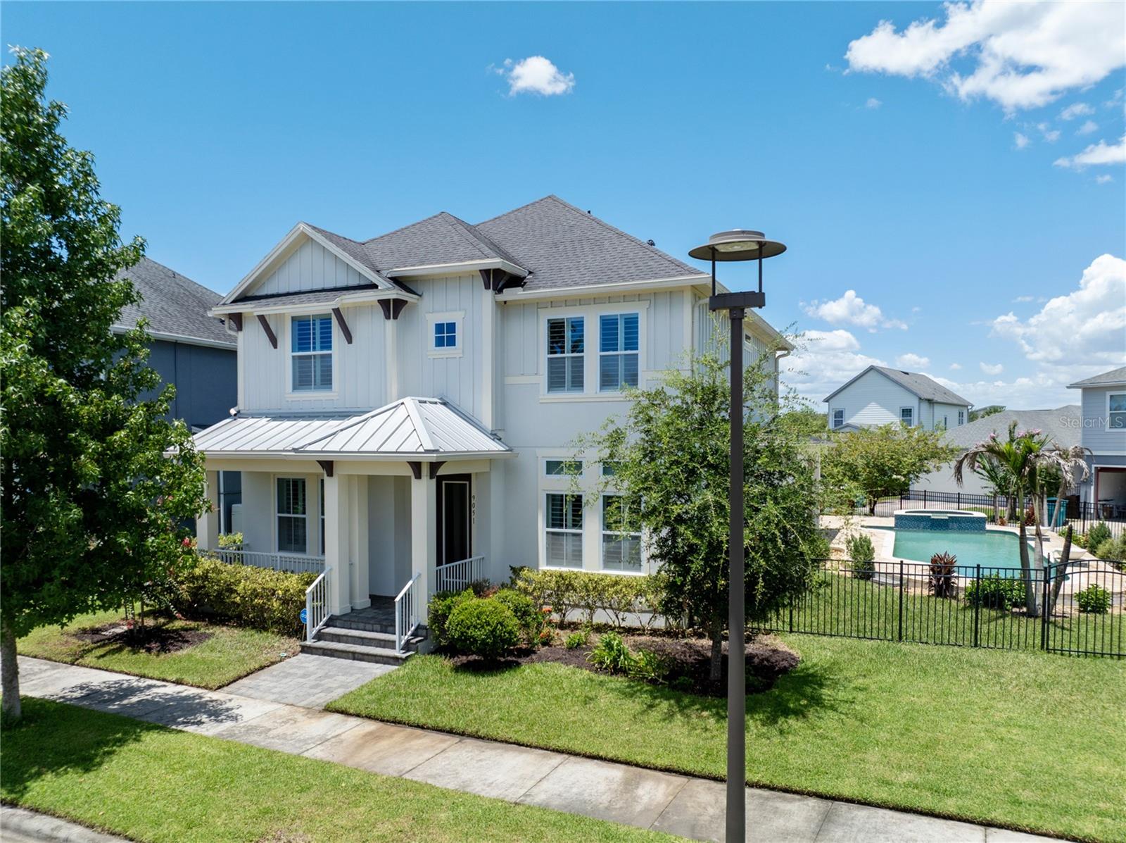 Every once in a while, a home comes along that simply feels different. This is one of them.Perfectly positioned on an oversized corner homesite in the heart of Laureate Park, this stunning David Weekley “Wembley” offers an exceptional combination of space, elegant design and a private resort-style backyard. From the inviting front porch and grand columned entry to the sweeping staircase and sun-filled gathering spaces, the home makes an immediate impression.Designed for both comfortable everyday living and effortless entertaining, the interior features soaring ceilings, wide-plank flooring, crown molding, plantation shutters and timeless architectural details throughout. The dedicated home office includes custom built-in cabinetry and a concealed Murphy bed, creating a versatile space that can easily transition from a productive workspace to comfortable overnight accommodations.At the heart of the home, the beautifully appointed kitchen is designed to bring people together. A substantial granite-topped island provides generous seating and preparation space, complemented by crisp cabinetry, a full-height designer tile backsplash, stainless steel range hood, built-in oven and microwave, separate cooktop, Bosch Home Connect dishwasher and a large walk-in pantry. A light-filled breakfast area opens directly to the covered lanai, while the adjoining living room offers an inviting setting for relaxed evenings and memorable gatherings. The home is also prewired for five-channel surround sound, complete with integrated speakers and volume controls.A spacious first-floor bedroom and nearby full bath provide a private and comfortable retreat for guests.Upstairs, the expansive primary suite features an elegant tray ceiling, crown molding and abundant natural light. The spa-inspired primary bath includes an oversized arched walk-in rain shower wrapped in marble-look tile, dual vanities and a generous walk-in closet. Two additional bedrooms, another full bath, a versatile loft and an exceptionally large laundry room with extensive cabinetry and a utility sink complete the upper level.Then step outside to the home’s true showpiece.Beyond the covered lanai, more than 1,000 square feet of paver decking surrounds a spectacular 38-by-13-foot heated saltwater pool. A raised spa, cascading waterfall features, pool lighting and a shallow lounging shelf create the feel of a private resort, while the fenced lawn and mature landscaping provide additional space to relax, entertain and enjoy the Florida sunshine.Thoughtful enhancements include whole-home water filtration with reverse osmosis, smart-home features, double-pane windows, overhead garage storage racks and an attached two-car garage.Laureate Park offers a vibrant Lake Nona lifestyle with resort-style community pools, the Laureate Park Aquatic Center, LP Fit, parks, playgrounds and an extensive network of scenic trails. The home is conveniently located near Medical City, Nemours Children’s Hospital, the VA Medical Center, the USTA National Campus, Orlando International Airport and Lake Nona’s exceptional dining, shopping and entertainment.This thoughtfully designed home brings together an impressive floor plan, a spectacular backyard and one of Lake Nona’s most desirable communities. Schedule your private showing today.