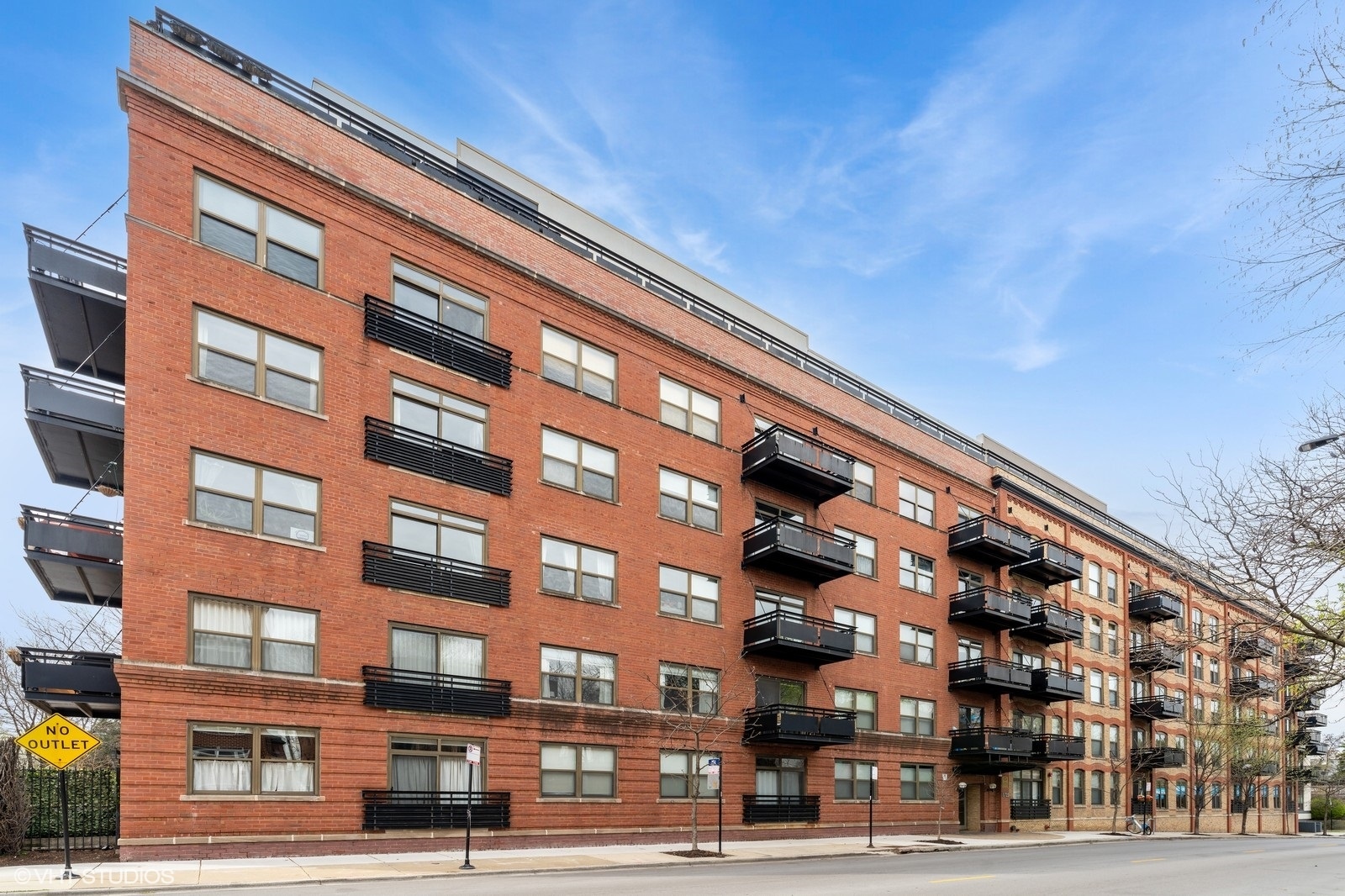 Rarely Available South-Facing Brick & Timber Loft in Regal Lofts - Lincoln Park! Welcome to this stunning 2 bed, 2 bath south-facing loft. On the opposite side of Diversey Parkway, this unit offers the perfect blend of classic character and modern updates in a prime Lincoln Park location. This sought-after floor plan features exposed brick and timber beams, hardwood floors, and abundant natural light pouring in through oversized windows with full southern exposure. The spacious open-concept living area includes a spacious kitchen with granite countertops, tons of cabinetry, stainless steel appliances, and a generous breakfast bar. The bright living room is anchored by a remote-start gas fireplace and seamlessly opens to a private balcony offering breathtaking skyline views-visible from both the great room and primary bedroom. A dedicated dining area features a modern light fixture and a convenient built-in nook, ideal for a bar setup or work-from-home space. The fully enclosed primary suite boasts custom Elfa closets and an en-suite bath with double vanity and soaking tub/shower combo. The second bedroom is fully enclosed with privacy glass providing separation and light.  Also boasting plush carpeting, and a custom Elfa closet. The second full bath, located off the main hallway, includes a tub/shower combo. Notable features include linen and coat closets, an in-unit washer/dryer, and a Nest Thermostat. Deeded exterior parking in a secured gated lot and a dedicated storage cage are included in the sale. Regal Lofts is a well-managed, pet-friendly elevator building offering an exercise room, dog run, ButterflyMX intercom system, and guest parking. Ideally located, this home is minutes from 90/94, the Diversey Brown Line, and bus routes. Enjoy being just steps to Hamlin, Wrightwood, and Che-Chi Wang Parks and having Midtown Athletic Club, Whole Foods, Costco, Hexe Coffee right outside your door!