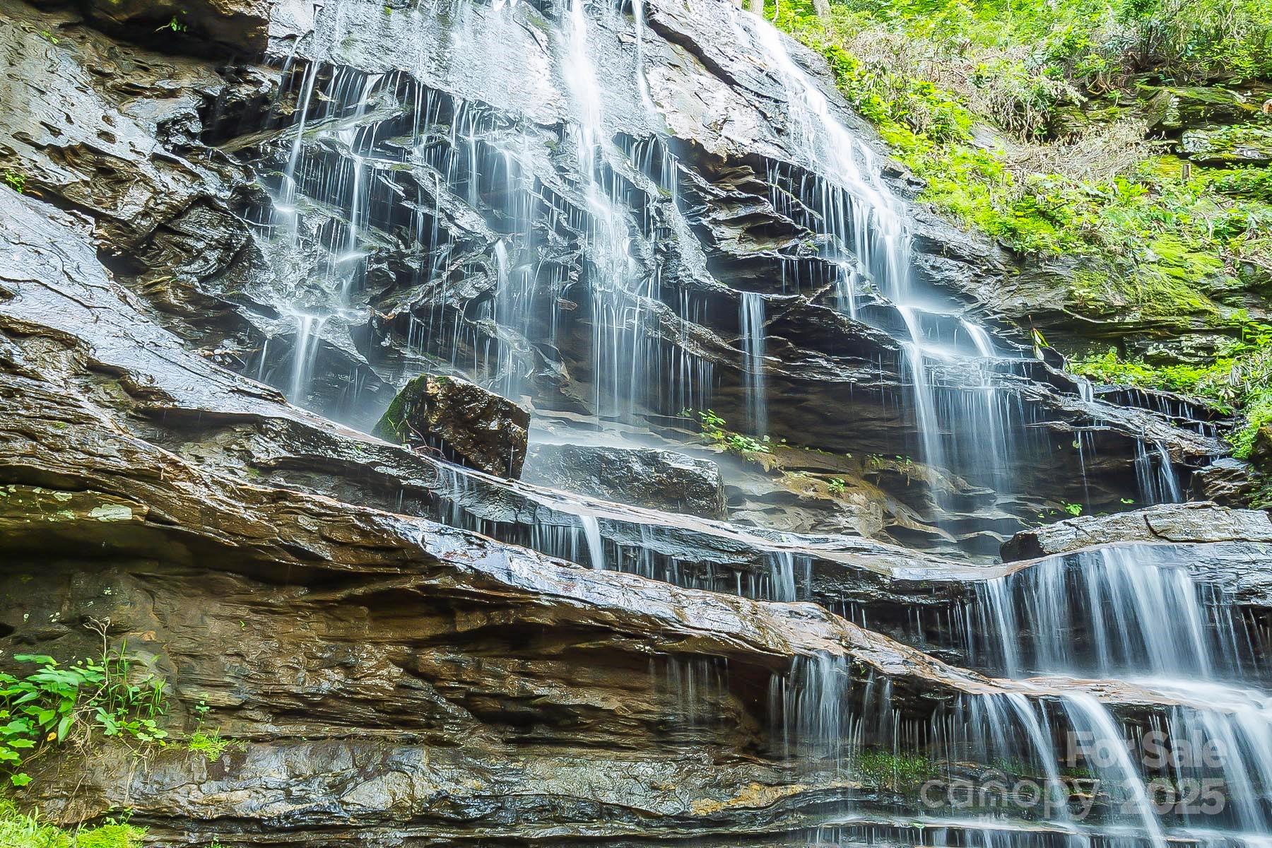 Enjoy a natural shower in the fresh flowing waters of WNC—your very own ±175-foot PERSONAL WATERFALL tumbling through the heart of ~17 private acres, framed by sweeping, unobstructed mountain views. This is not just another mountain tract; it’s a once-in-a-lifetime sanctuary where rare natural wonders meet modern readiness!!!Imagine stepping outside to hike or bike your private trails that lead to a dramatic cascade, cooling off beneath a natural shower formed by the rock ledge, or exploring sandy-bottom creeks that meander through your land. A tranquil man-made pond adds to the peaceful setting, while abundant wildlife makes every visit feel like stepping into a nature preserve. Each day here brings awe, serenity, and a renewed sense of connection—because this isn’t just land, it’s a lifestyle.The property already offers multiple cleared homesites, each carefully placed for privacy and breathtaking vistas. Whether your vision is a mountain lodge, a modern glass retreat, or multiple cabins for guests and family—with underground power in place.Set within the secure, gated community of New Forest Mountain, this tract offers the best of both worlds: total peace and seclusion, with convenient access to the region’s best destinations. Just minutes from local dining and essentials, you’re also centrally located to major hubs: ~1 hr to Asheville or Greenville/Spartanburg (GSP International Airport), ~1.5 hrs to Charlotte (CLT International Airport), and easy drives to Lake Lure, Chimney Rock, and Hendersonville for lakeside recreation, shopping, and festivals.Highlights RECAP!***Personal ±175-ft waterfall—private, dramatic, and awe-inspiring***17+/- acres with mountain views, pond, creeks, and trailsMultiple cleared homesites with privacy and stunning vistasUnderground power & water hookups already in placeGated community for peace and securityEasy access to Asheville, Greenville, Charlotte, Lake Lure & moreThis tract is being offered as a standalone opportunity, perfect for the buyer who values exclusivity and a one-of-a-kind property. For those seeking even more land, views, and features, additional acreage can be acquired for a premium package, creating a larger estate or investment opportunity rarely seen in Western North Carolina.Opportunities like this are virtually impossible to duplicate at this price—or at all. Proof of funds or pre-approval required to tour (agent access only). With interest rates dropping and demand rising, this gem won’t last long. Call today to walk the land, hear the water, and feel the magic for yourself!