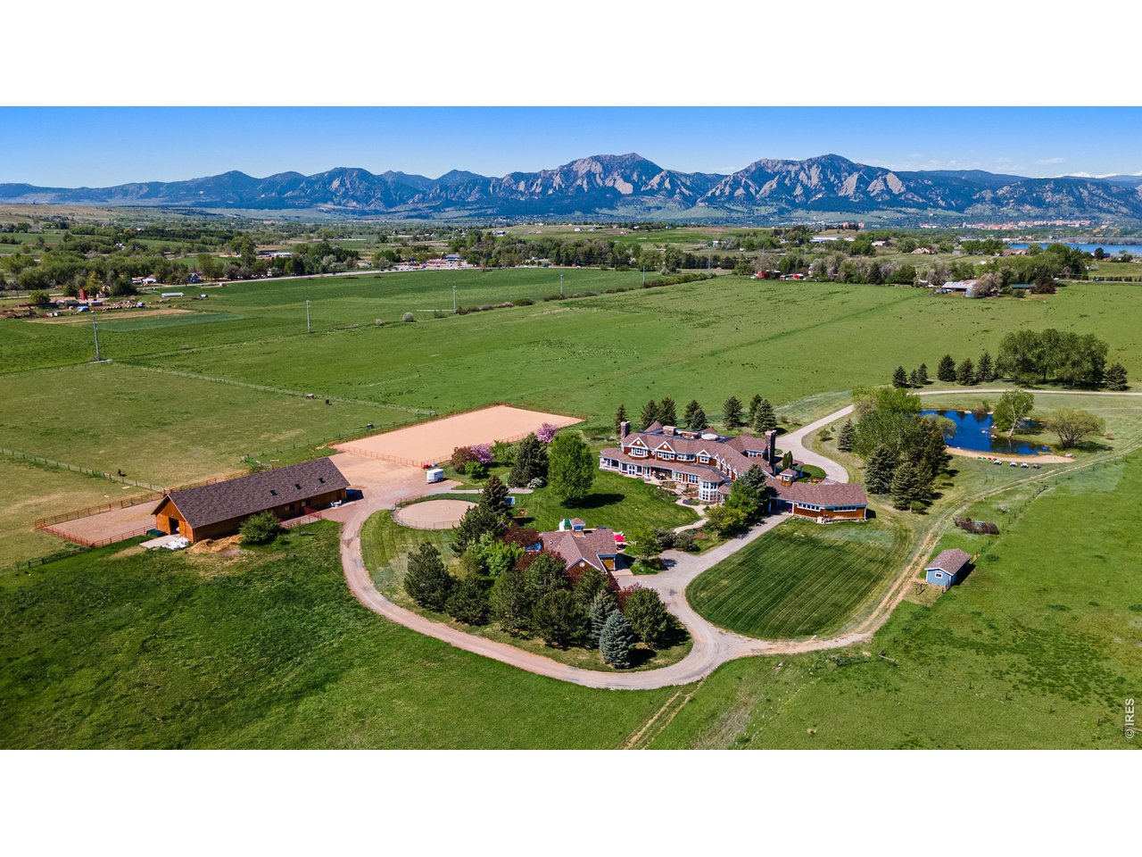 Situated on nearly 40 private acres surrounded by protected open space, this remarkable estate represents one of Boulder's most exceptional offerings-where architectural beauty, privacy, and an unparalleled Colorado lifestyle come together in rare harmony. Framed by unobstructed views of the Flatirons, Longs Peak, and the Continental Divide, the setting feels both breathtakingly expansive and deeply serene, offering a level of tranquility seldom found this close to town. A gated drive leads to a timeless Nantucket-inspired residence, where cedar siding, wraparound verandas, and a stately porte-cochere create an unforgettable arrival. Thoughtfully designed to balance refined elegance with everyday livability, the seven-bedroom custom home showcases exceptional craftsmanship, generous gathering spaces, an elevator, and seamless indoor-outdoor flow. A one-bedroom apartment with a separate lower-level entrance provides flexibility for guests, live-in support, or an au pair. Created for those who value land, lifestyle, and exceptional amenities, the estate offers features rarely found in Boulder, including a state-of-the-art seven-stall barn with heated wash bays and riding arena, a private pond, resort-style pool and pool house, rooftop hot tub, expansive outdoor living spaces, and a six-car garage. Tailored for equestrian enthusiasts or those seeking a grand, versatile retreat, the property is equally suited for outdoor lovers, car collectors, artists, or musicians seeking space to pursue passions without compromise. Wildlife roams the grounds, sunsets stretch across the mountains, and every vantage point reinforces the rarity of what exists here-a private sanctuary that feels worlds away, yet remains just minutes from Boulder's dining, trails, and cultural amenities. More than a home, this is a legacy estate-an extraordinary opportunity to own one of Boulder's most iconic properties.