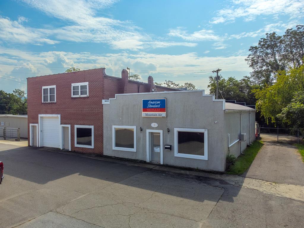 Prime Commercial Opportunity in Hayesville! Just steps from the town square, this rare offering includes two interconnected commercial buildings and a rear parking lot on three parcels, providing outstanding flexibility for investors or owner-occupants. Equipped with 3-phase power to support industrial use. Owner financing available with substantial down payment. Building 1 is a spacious, single-story warehouse with an open layout, roll-up garage door, private bathroom, and multiple office rooms—ready to be customized for storage, manufacturing, or creative use. Building 2 features a large 3-bed, 2-bath apartment upstairs with a covered porch—ideal for rental income or owner occupancy. Downstairs includes another sizable warehouse with roll-up doors on both ends, plus an additional office or workshop space. With potential for three income streams in Hayesville's growing downtown, and demand high for both residential and commercial rentals, this mixed-use property offers exceptional investment value.