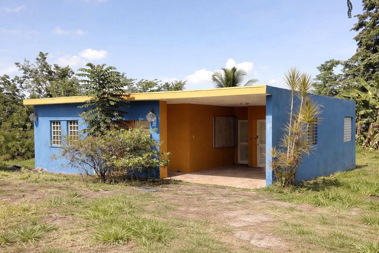 One or more photo(s) has been virtually staged. Located in San Juan, the capital of Puerto Rico, this property offers a rare opportunity in one of the island’s most central and convenient areas. Situated on a quiet cul-de-sac, the home features a spacious lot with mature fruit trees and ample outdoor space, ideal for expansion or future development. While the property requires improvements, it presents strong potential for investors or buyers looking to customize and add value. Enjoy a peaceful, countryside atmosphere while remaining just minutes from the city, major roadways, shopping, dining, and everyday conveniences